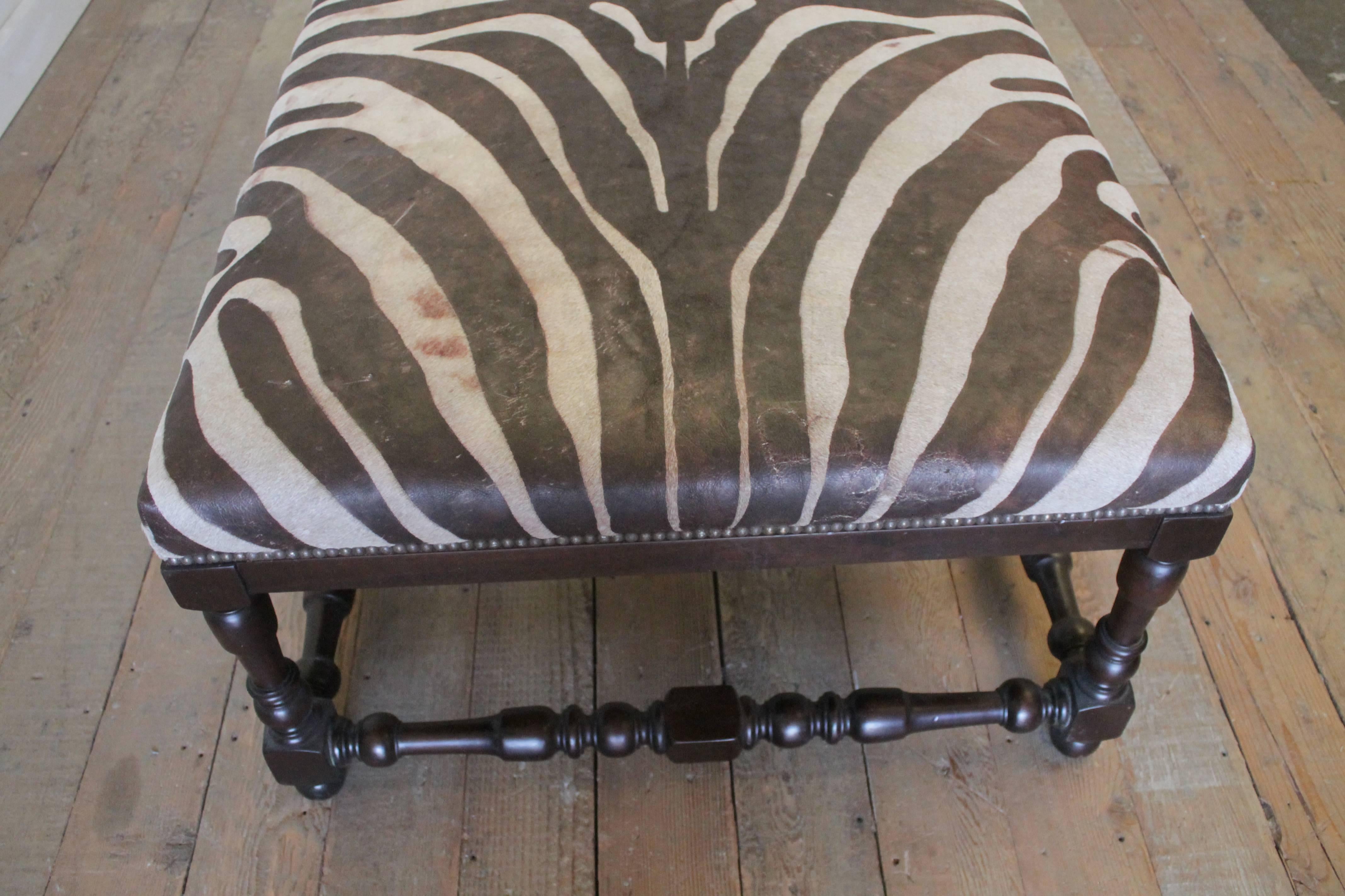 Beautiful cocktail ottoman with brown and cream colored hide with zebra pattern. The base is a nice espresso brown, with turn legs and stretchers.
Finished with a nailhead trim.
Measures: 44 x 36 x 21 H.