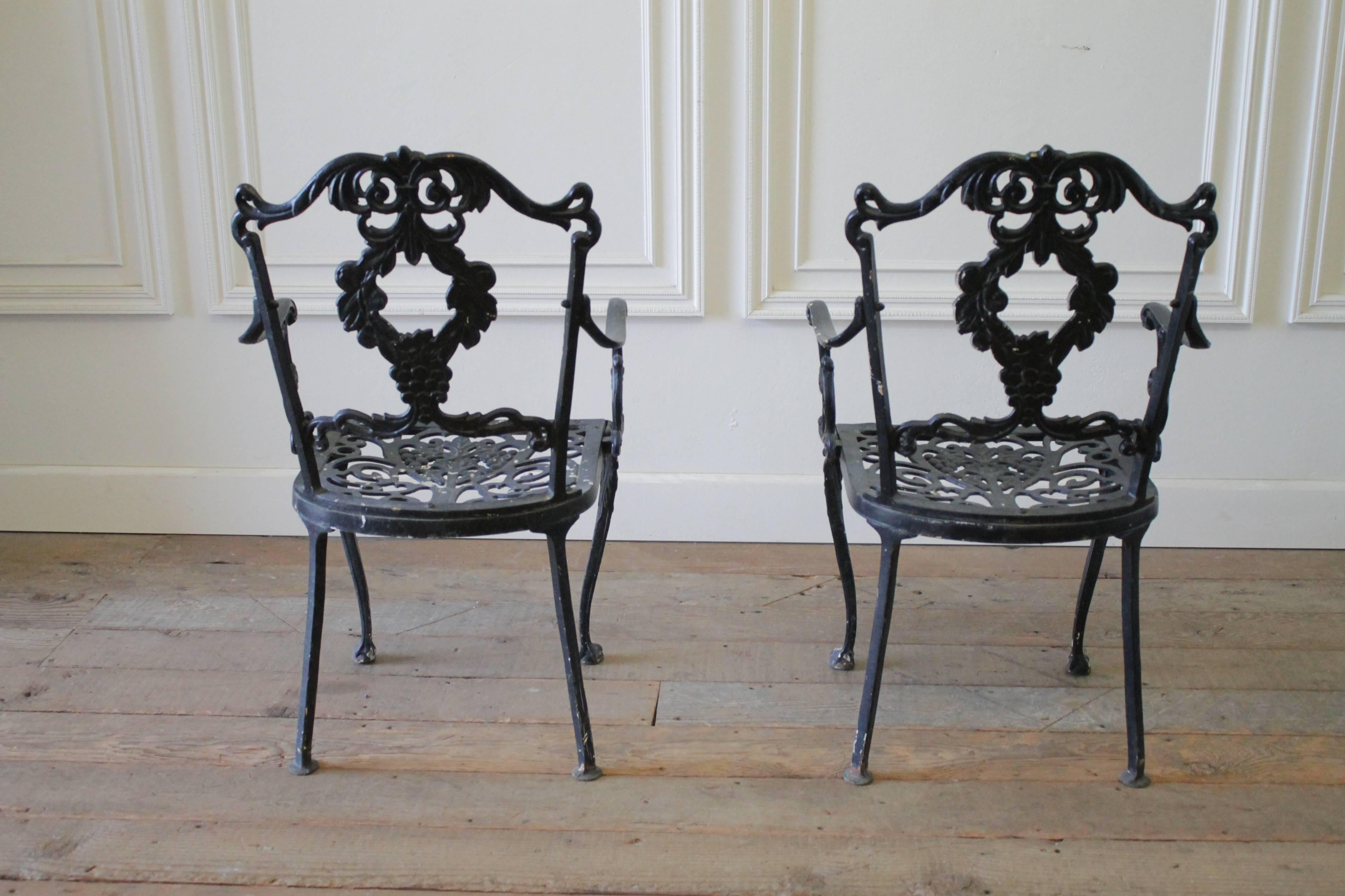 Black cast iron garden chairs with decorative backs. These pair of arm chairs can be refinished in a powder coat or outdoor paint.
Measures 20