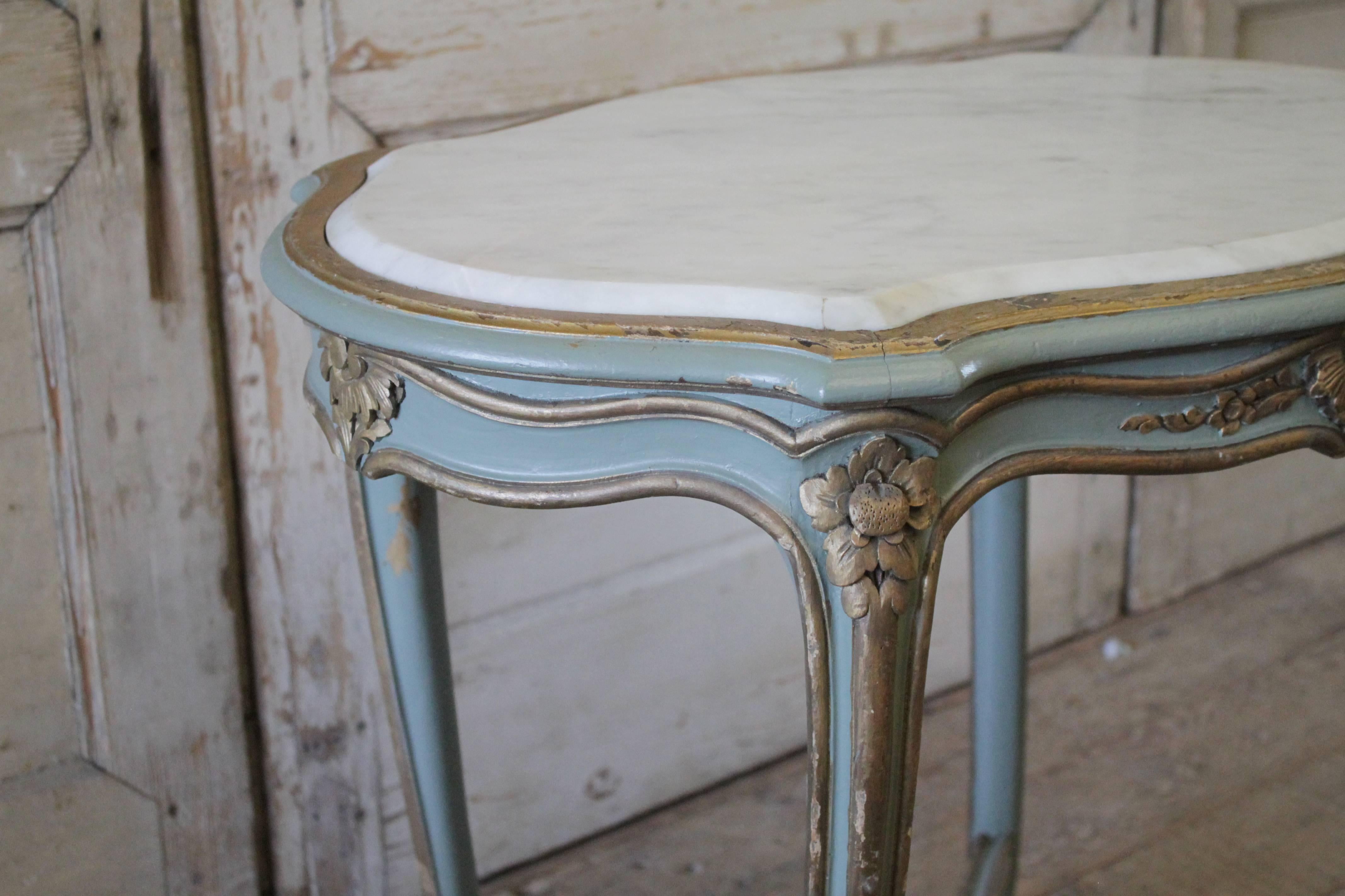 Painted in a blue-green grey color, with gilded highlights. Subtle distressed edges, and a white marble inset top. c1940, legs are sturdy, table is ready for daily use.
Measures: 31