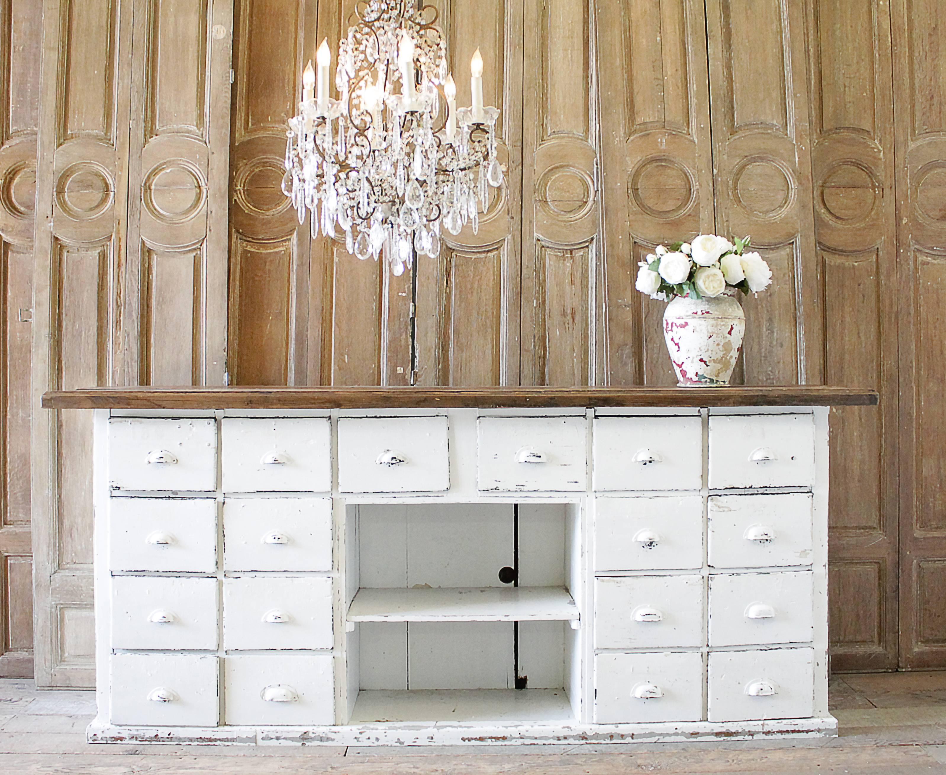 Farmhouse style cabinet, large with multiple working drawers, and thick wood plank top. This cabinet has the original bin pull handles, and each drawer has a number you can see through the white paint. The paint is pure white, with chippy areas
