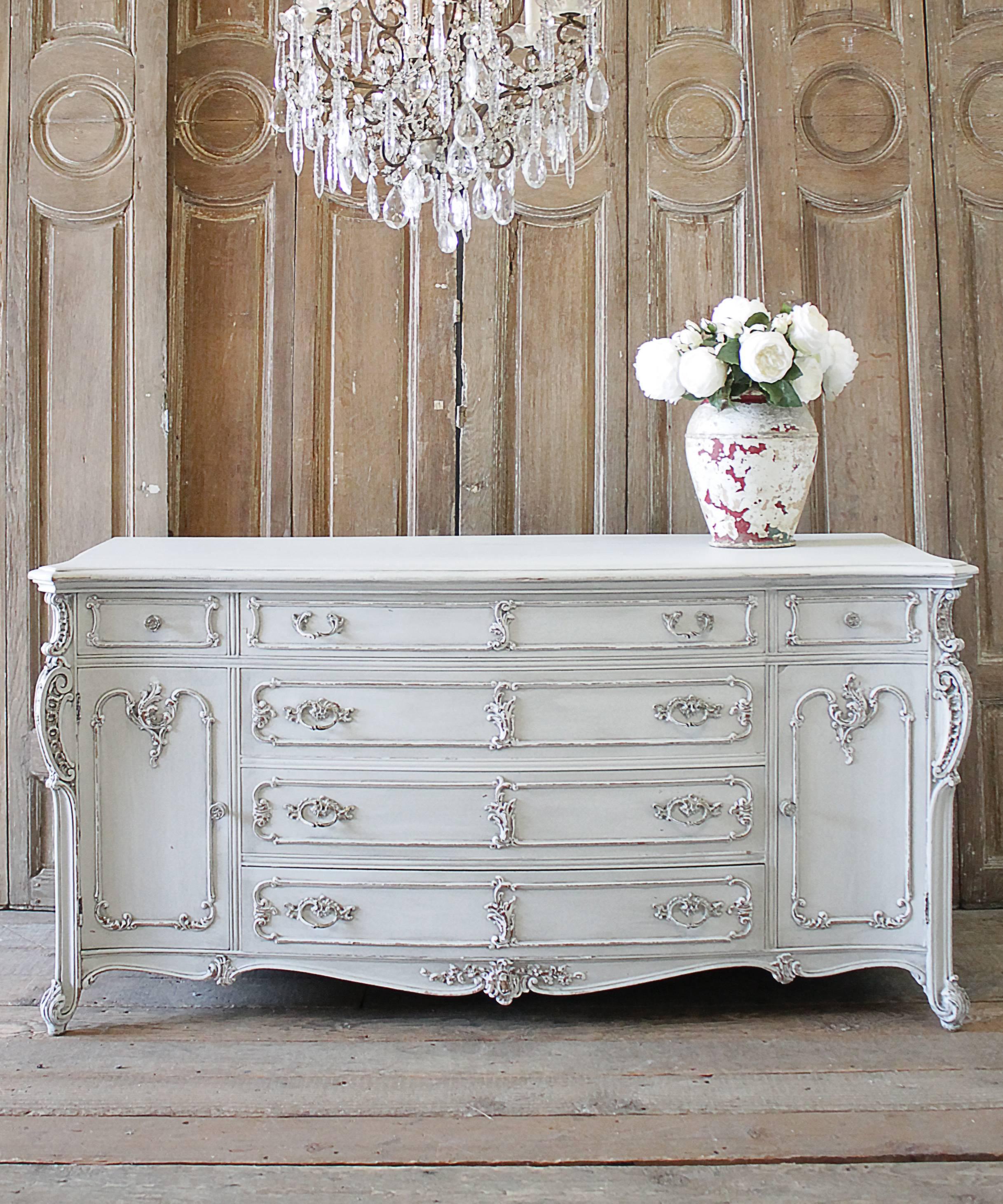Beautiful Louis XV style painted and carved dresser. This has been painted in a soft oyster white finish, with subtle distressed edges, and finished with an antique glaze. There are six working drawers that open and close with ease, and two doors,