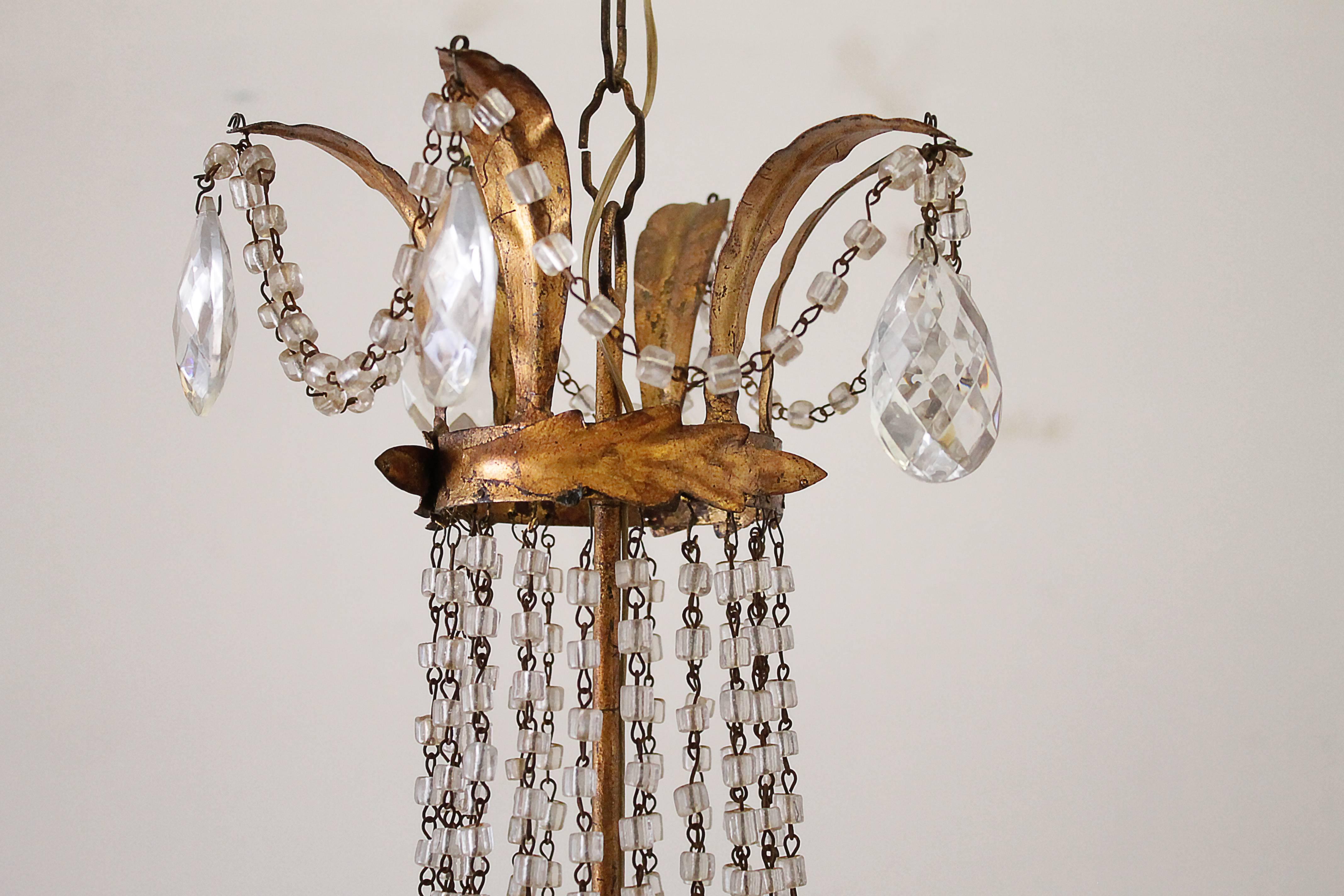 20th century Italian Macaroni beaded tole chandelier with six lights. The sockets have all been newly replaced, and is ready for a US bulb, with faux wax candle cover sleeves, ready to hang. A beautiful gilt antique patina finish. This chandelier
