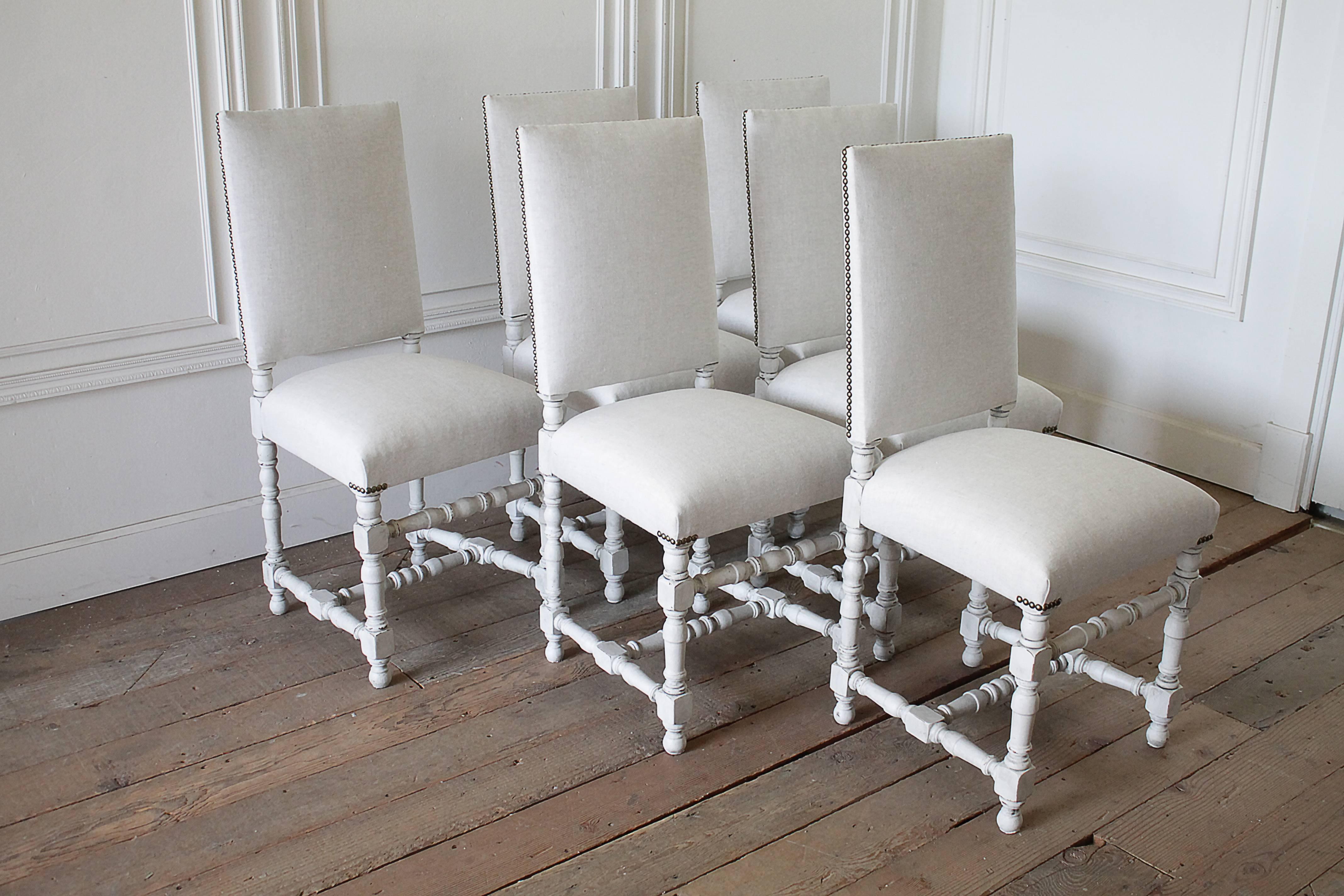 Set of 6 French Style Painted and Upholstered Dining Chairs
Finished in an off white with subtle distressed edges on the legs, and upholstered in a heavy Belgian linen, in a natural flax.  Each chair is solid and sturdy ready for everyday use.  The
