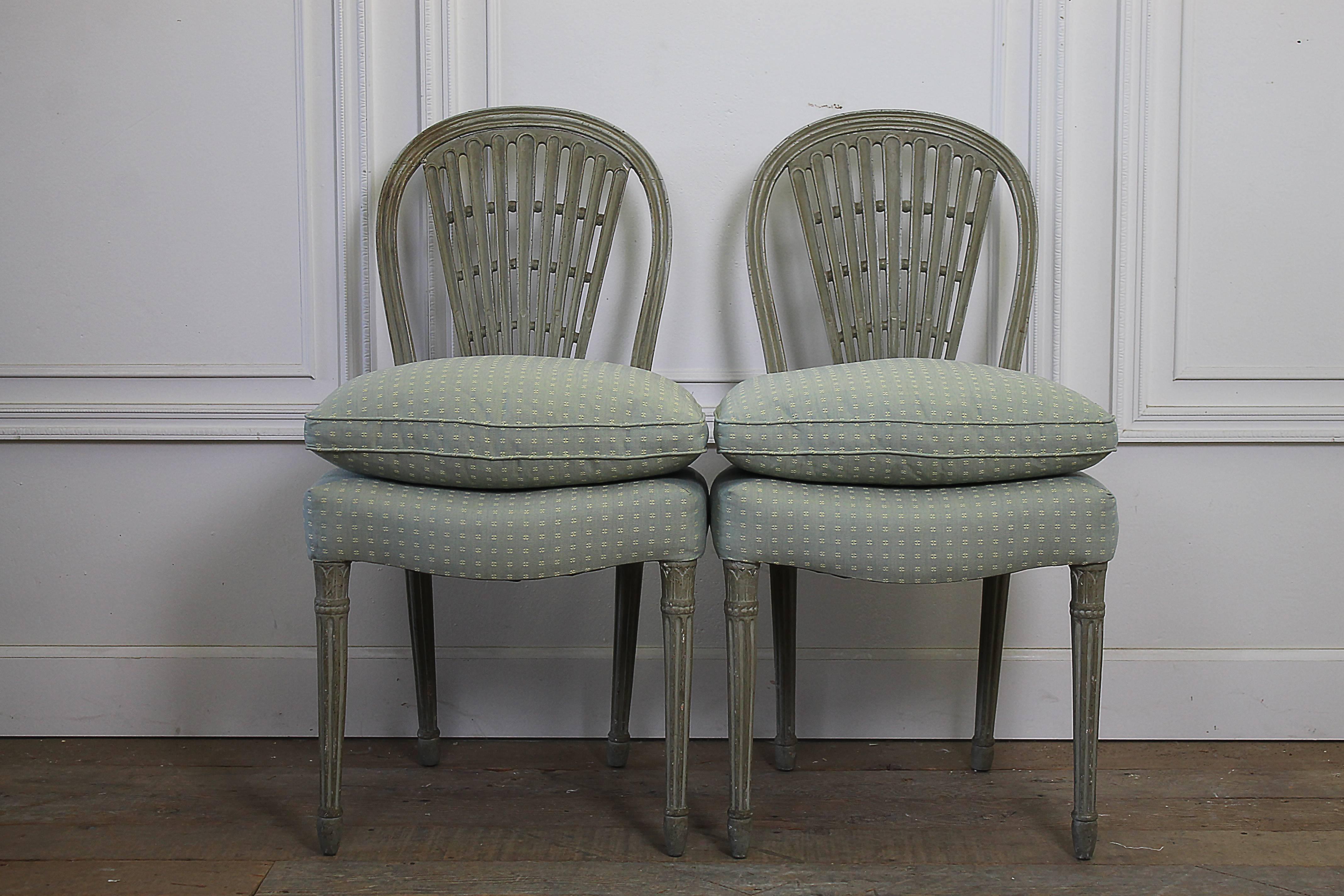 Early 19th Century Painted Upholstered Wheatsheaf Style Gustavian Dining Chairs
These are a set of 2 side chairs and 2 arm chairs, painted in a Gustavian Grey color, with subtle distressing.  Upholstery is as found, looks newer and very clean, seats