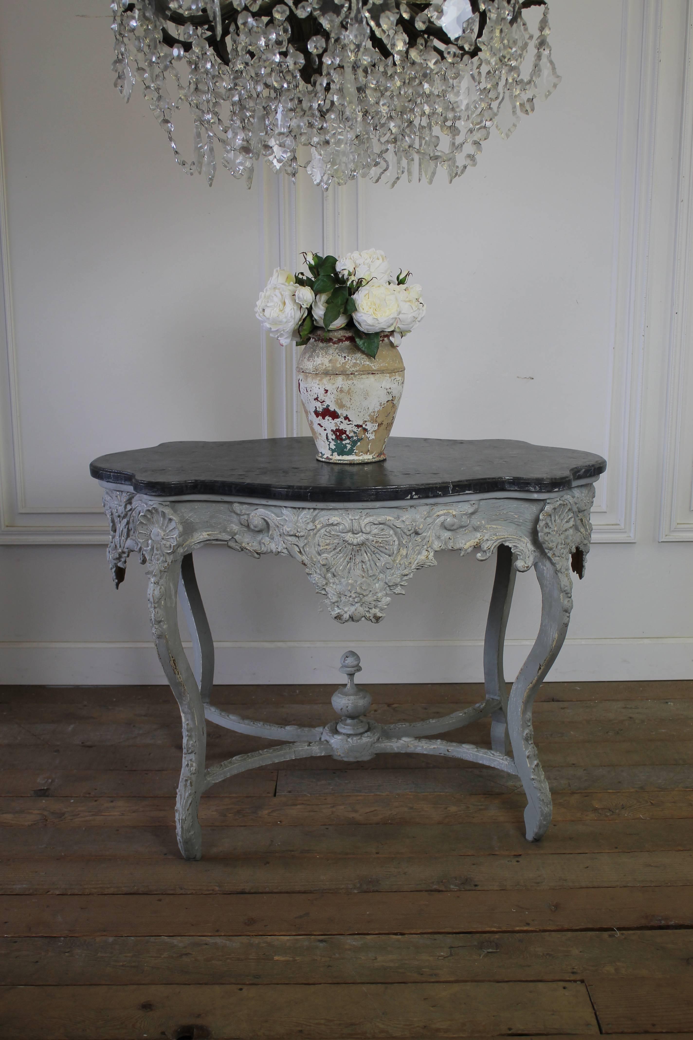 19th Century Painted and Carved Center Table with a faux marble painted top.  The base is painted in a pretty grey color with distressed areas, and aged patina.  The base is wood carved with gesso.  The table is sturdy, ready for use.
Measures: 45