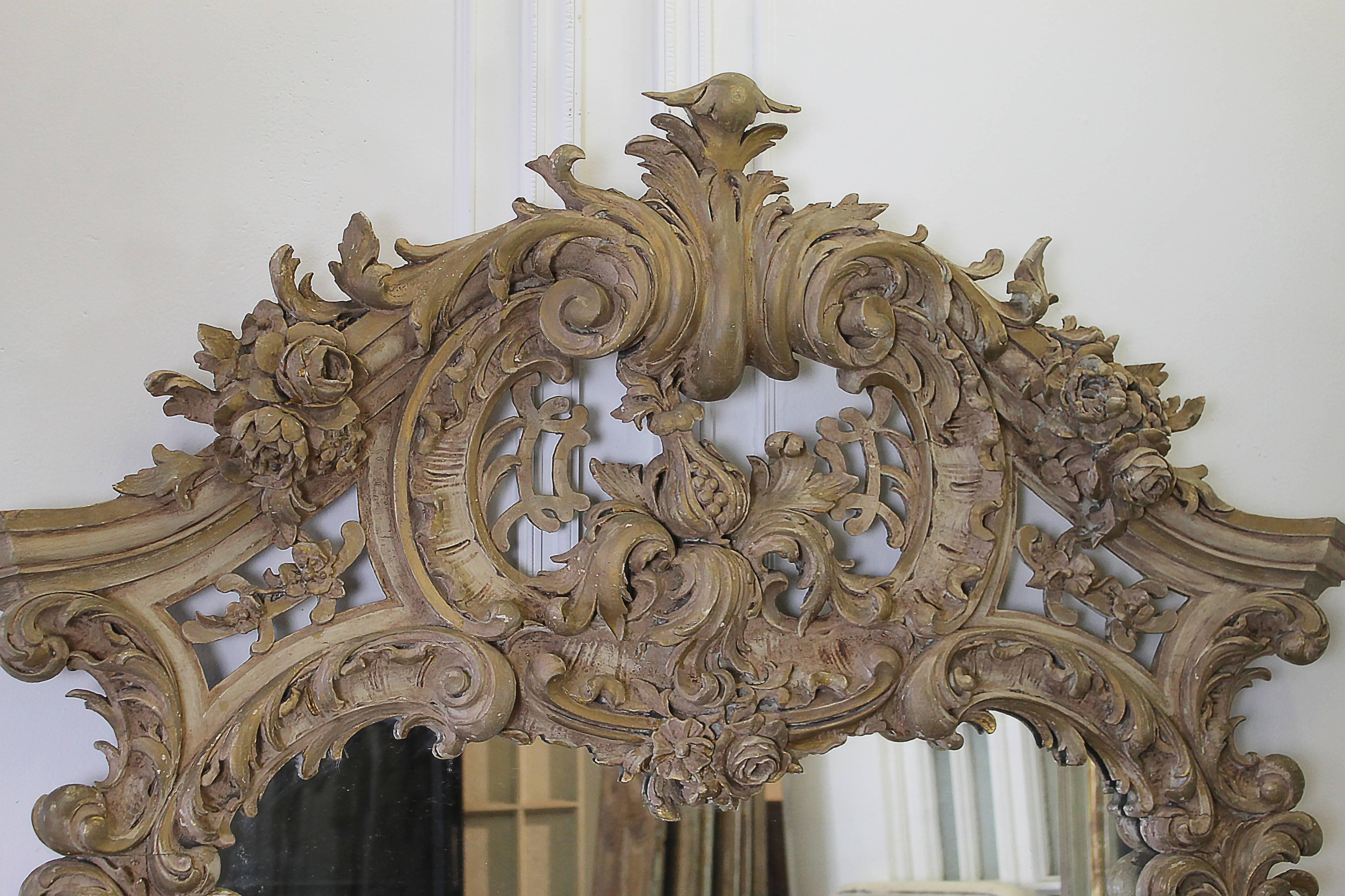 Early 20th Century Antique Wood Carved and Painted French Mirror 
A large grand crest, with scrolls and rose carvings cascade along the top, and wrap down the sides of this mirror.  Each corner at the bottom have carved cartouche and rose carvings. 