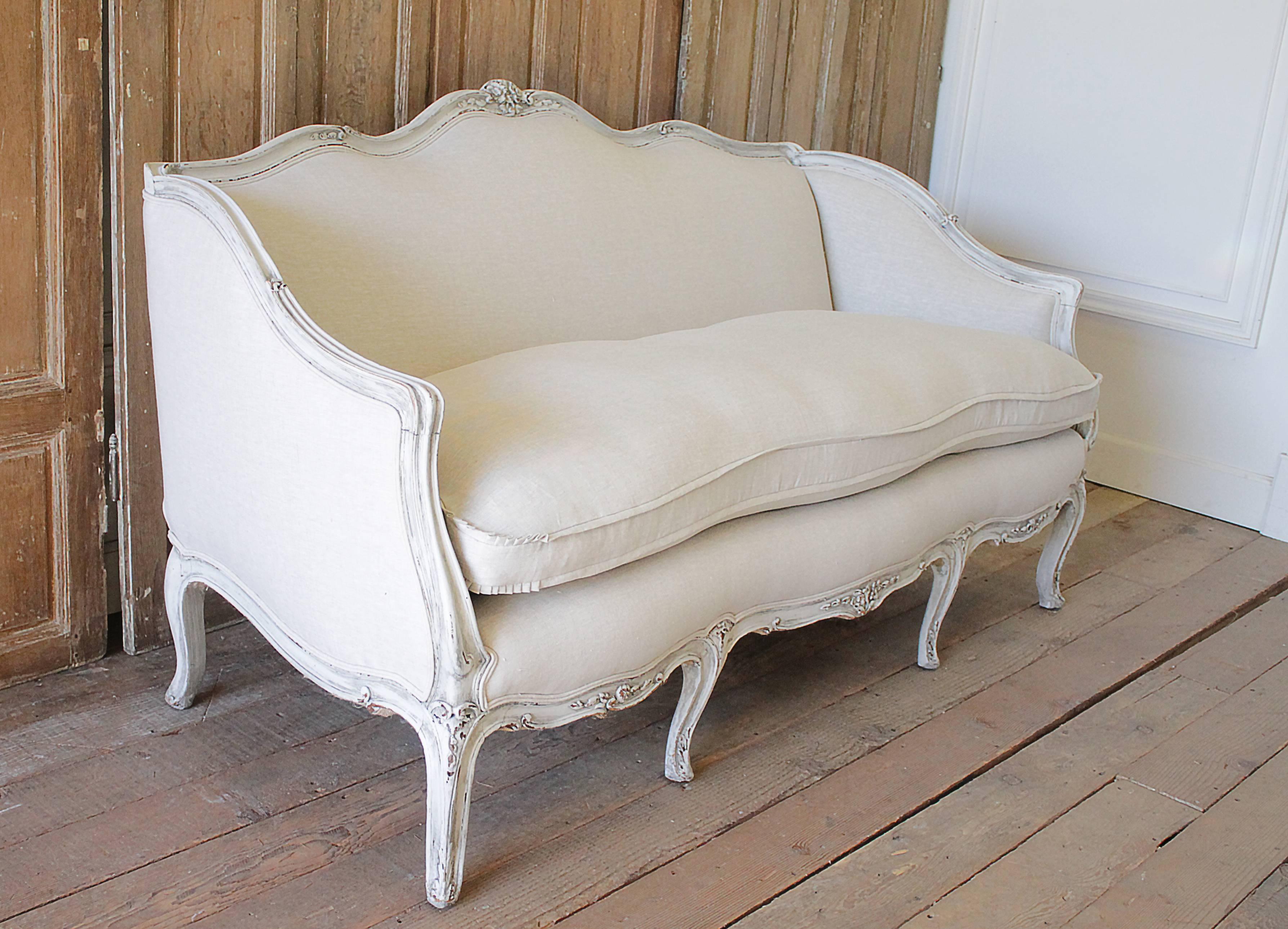 19th Century Carved and Painted Louis XV Style Sofa Upholstered in Organic Linen
Antique French sofa has our signature oyster white painted finish, with subtle areas of distressing, and finished with a hand glazed patina.
This has been reupholstered