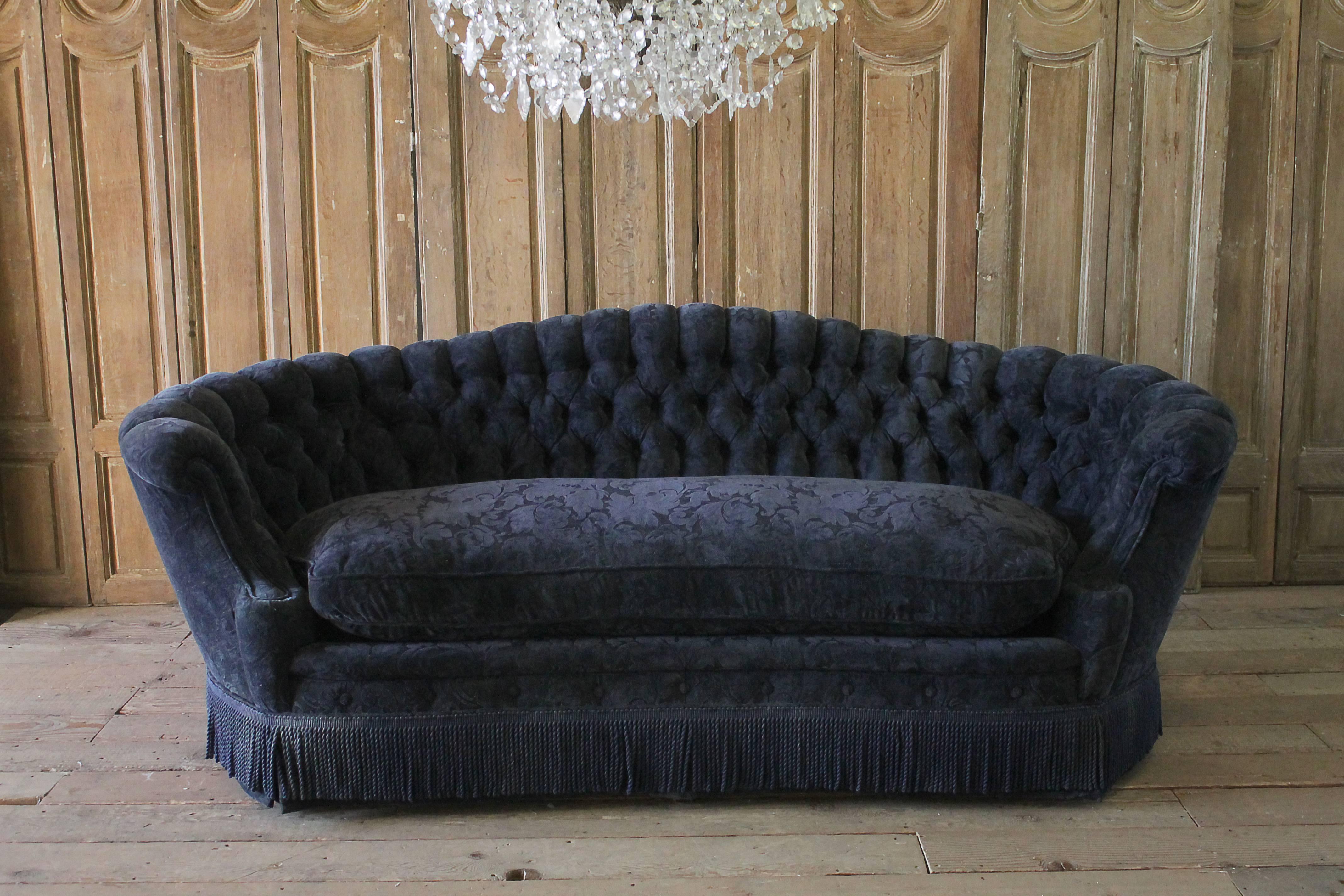 Vintage button tufted sofa in the Victorian style. A large plump down cushion, very comfortable, a solid frame. This has a deep navy blue velvet chenille upholstery that is in good condition. Slight areas of fading, or use. We offer reupholstery,