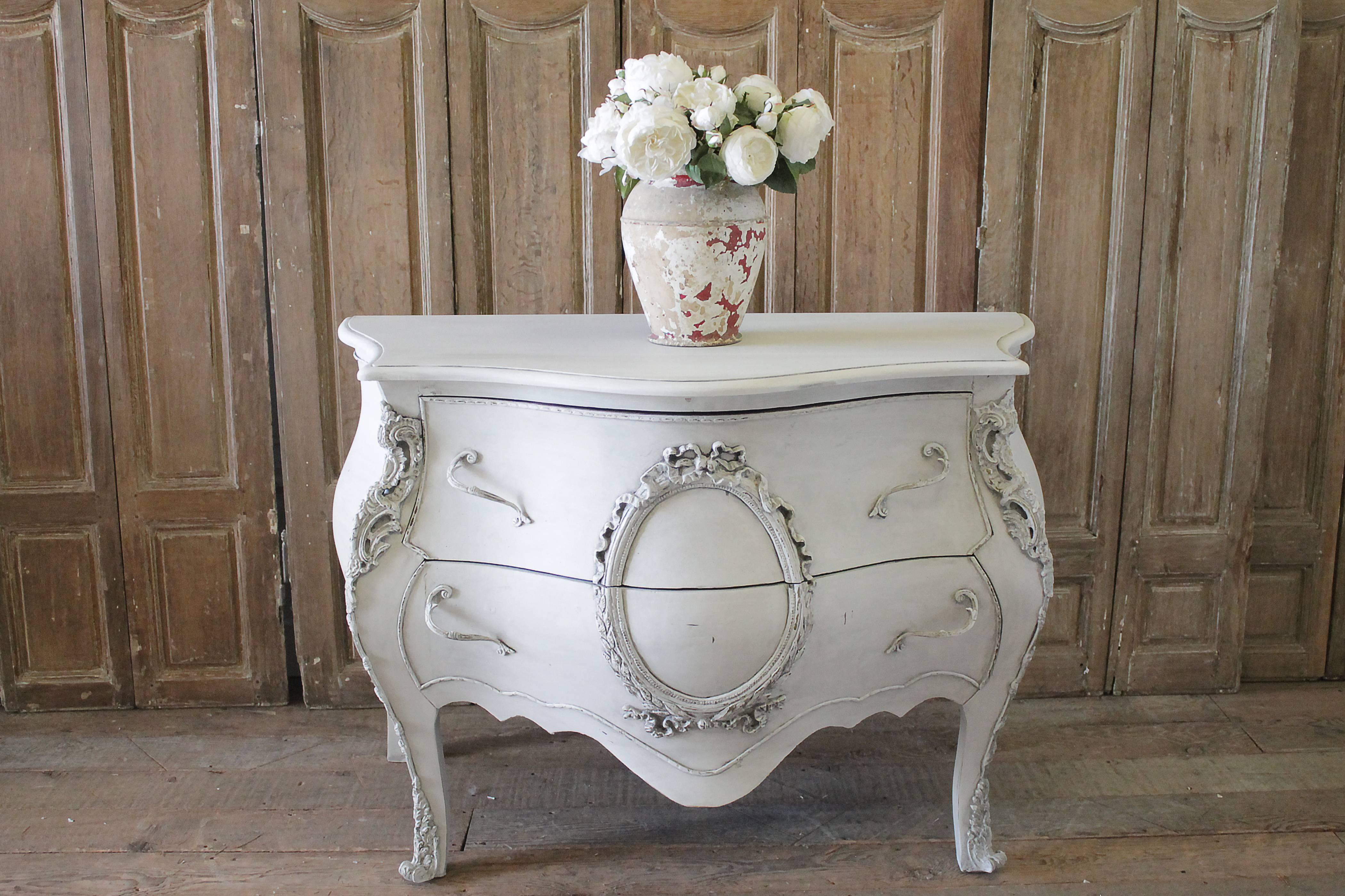 20th century carved and painted Louis XV style bombe commode
Painted in our oyster white finish, with subtle distressed edges, and antique glazed patina. The 2 drawers are finish with a dovetail construction, and original hardware. The ornaments