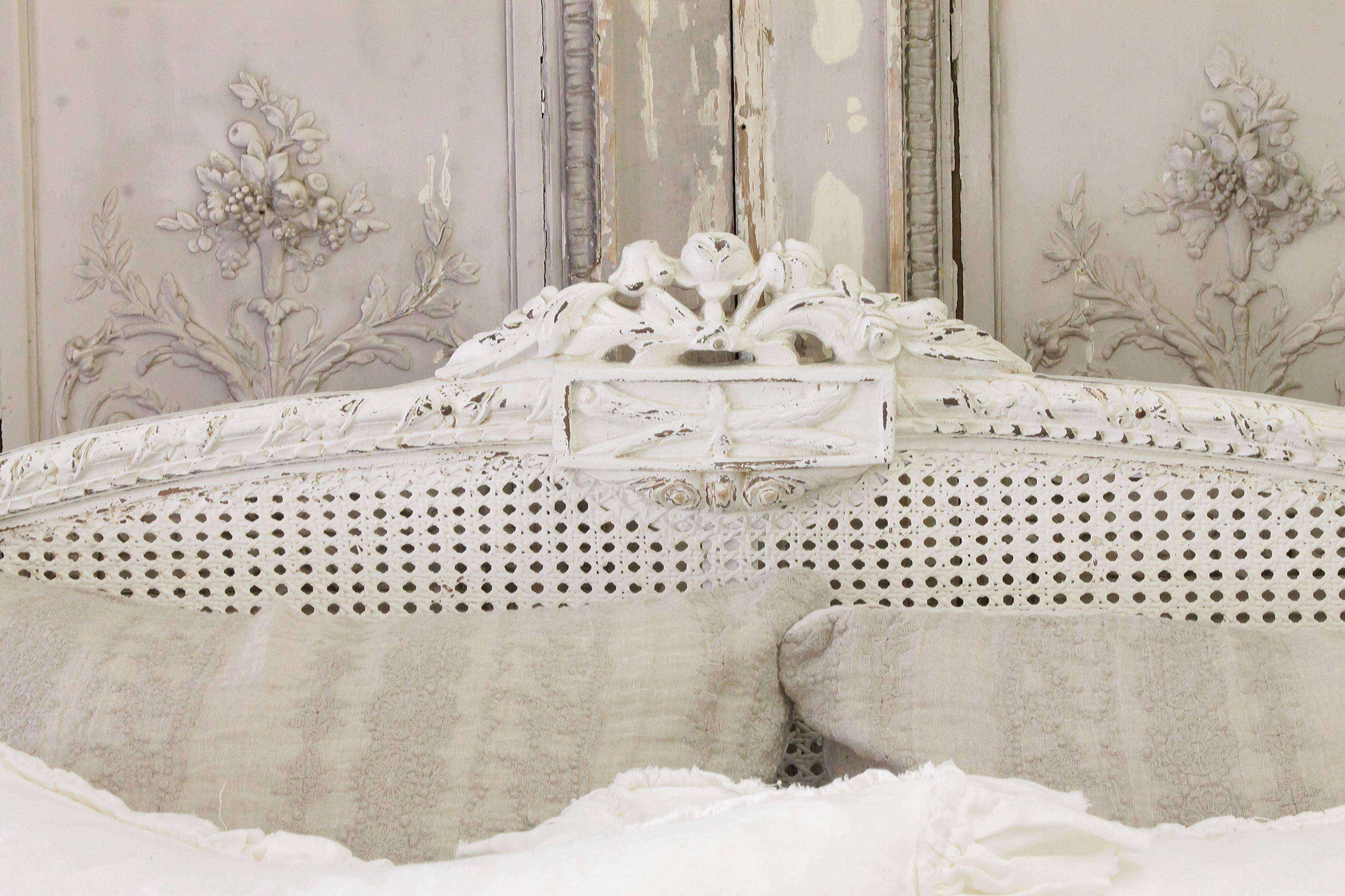 This beautiful Louis XVI French bed that is finished in a soft white. Original rails, and new bed slats are included. 
The cane is in excellent condition. The bed uses lag bolt construction, it is very sturdy when put together.
Shown with a queen