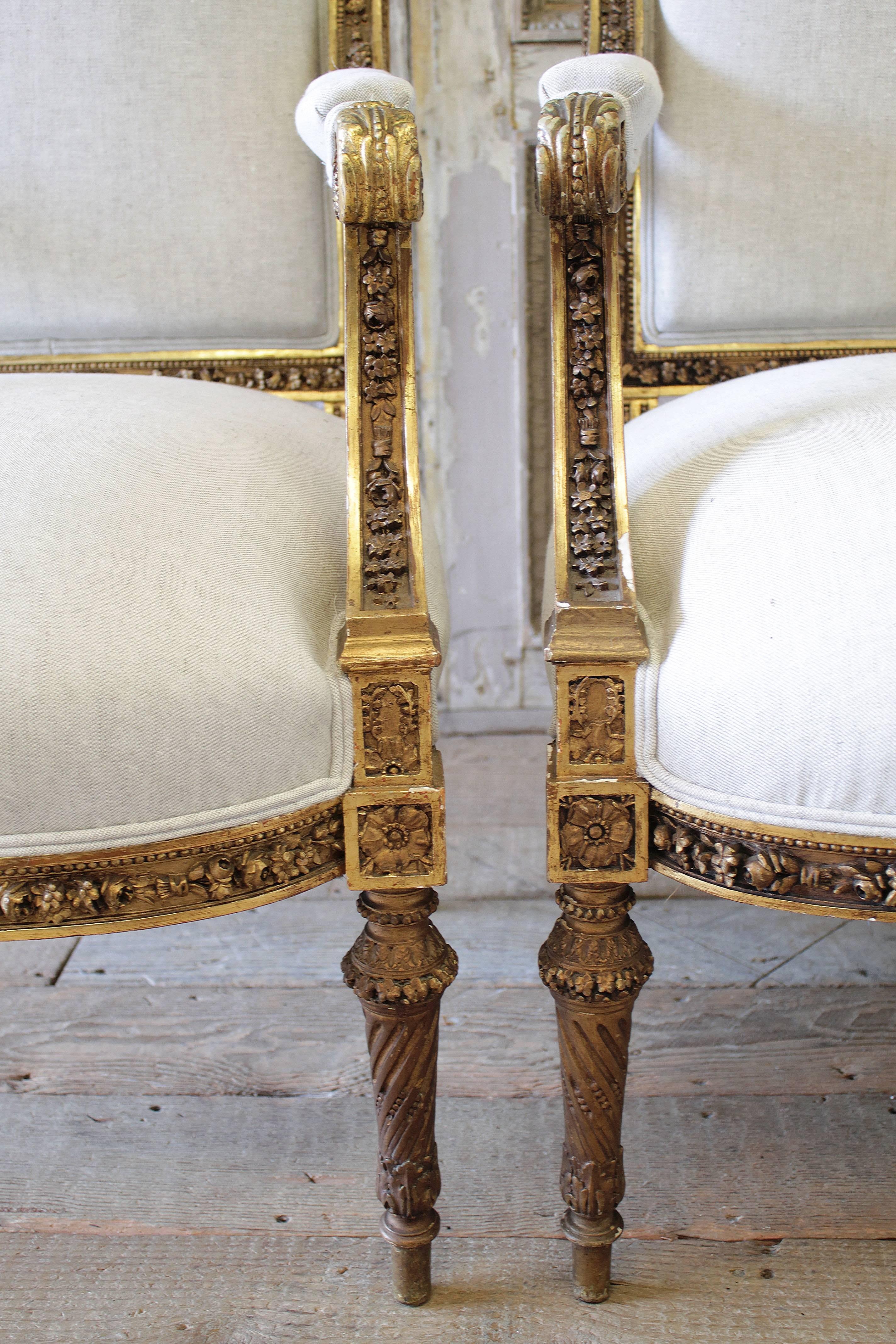 Fantastic pair of elegant giltwood chairs, with detailed rose and floral carvings throughout. The pair have been reupholstered in a 15oz natural Belgian linen. Seats have eight way hand tied springs, with new foam and cotton and horse hair.