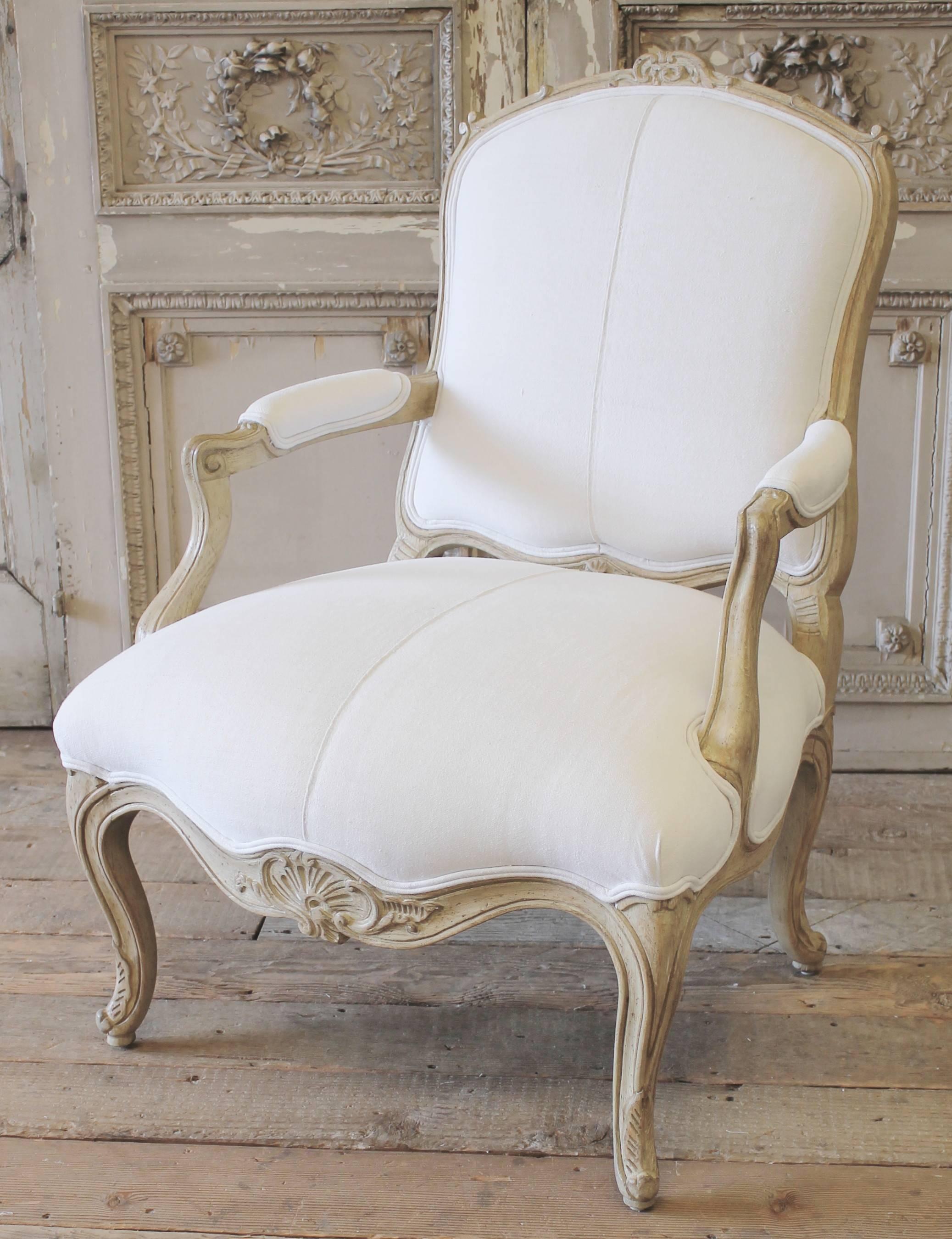 Classic Louis XV style chair in natural wood color, upholstered in 200 year old French grainsack linen. The upholstery is very clean, the back is another grainsack that is a more oatmeal color with faded red stripes.
The chair is very solid and