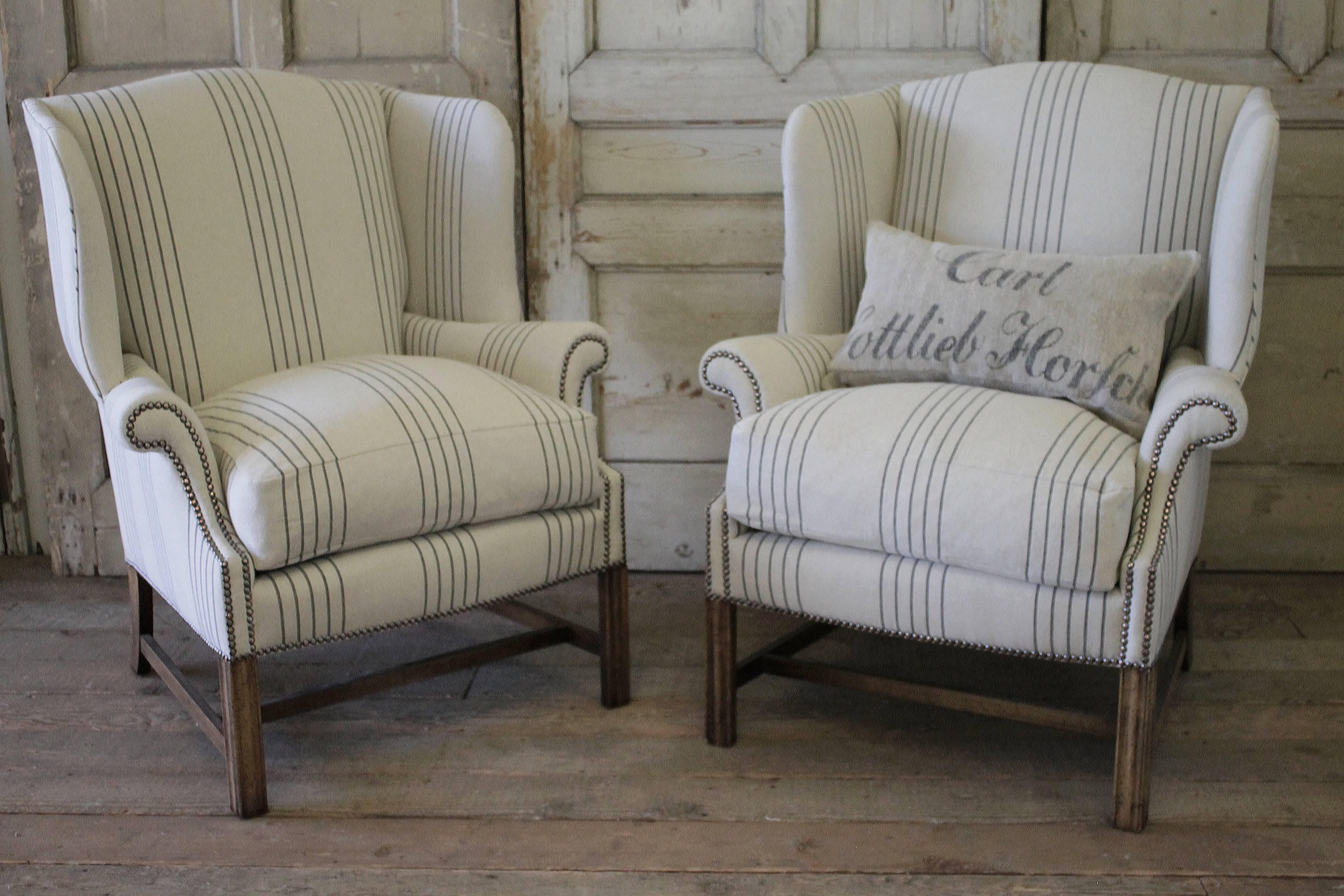 Vintage wing chairs, circa 1960 upholstered in a French Linen we designed. The cushion is a down feather and slip covered. The nailhead trim is antique bronze.
     
