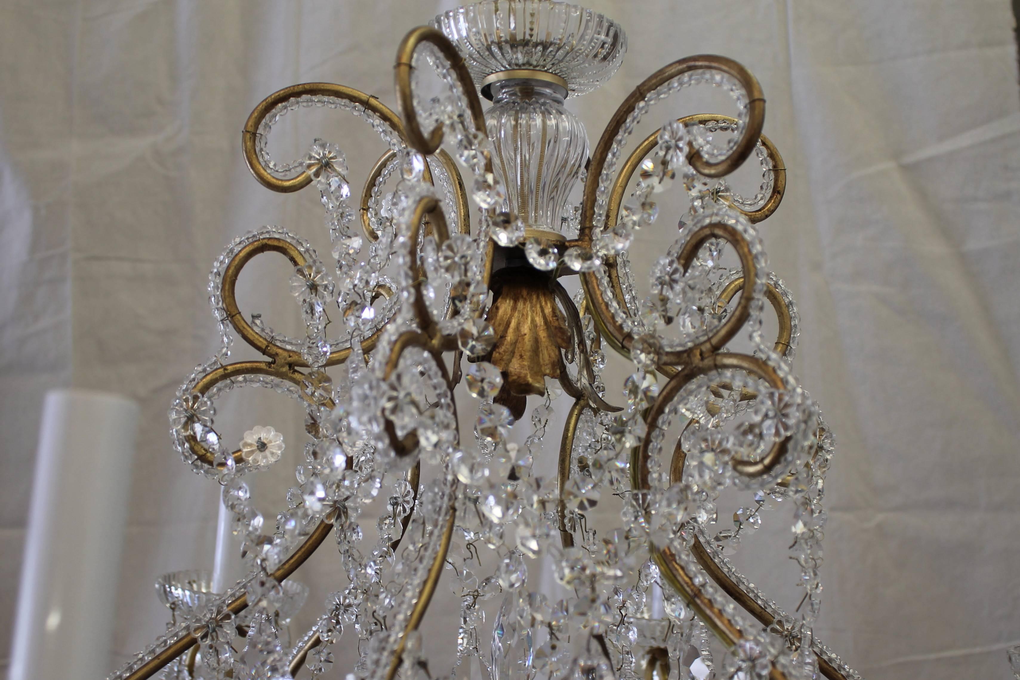 This is part of our own collection of reproduction chandeliers. Custom designed and made in Italy, our chandelier frame is painted in an antique gold, with beautiful French pendant crystals. The arms and frame are all beaded to give added sparkle.