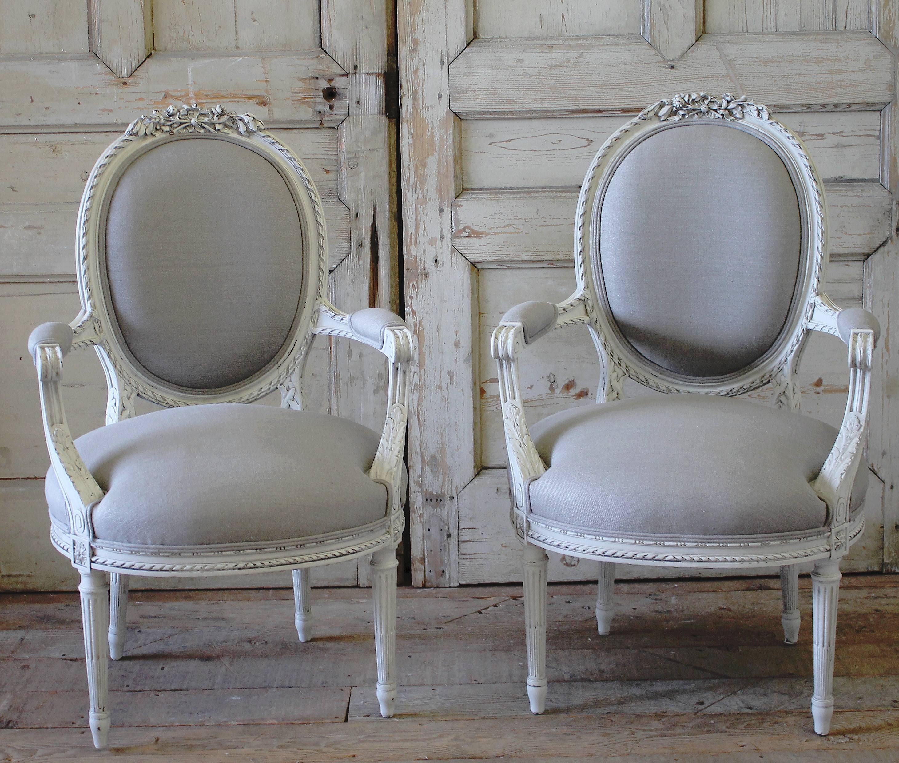 Beautiful carved French open-arm chairs, painted in our signature oyster white finish. Our oyster white is a soft white, with subtle cream and greyish tones. Hand distressed with and antique rubbed glaze finish, to give the look of old original