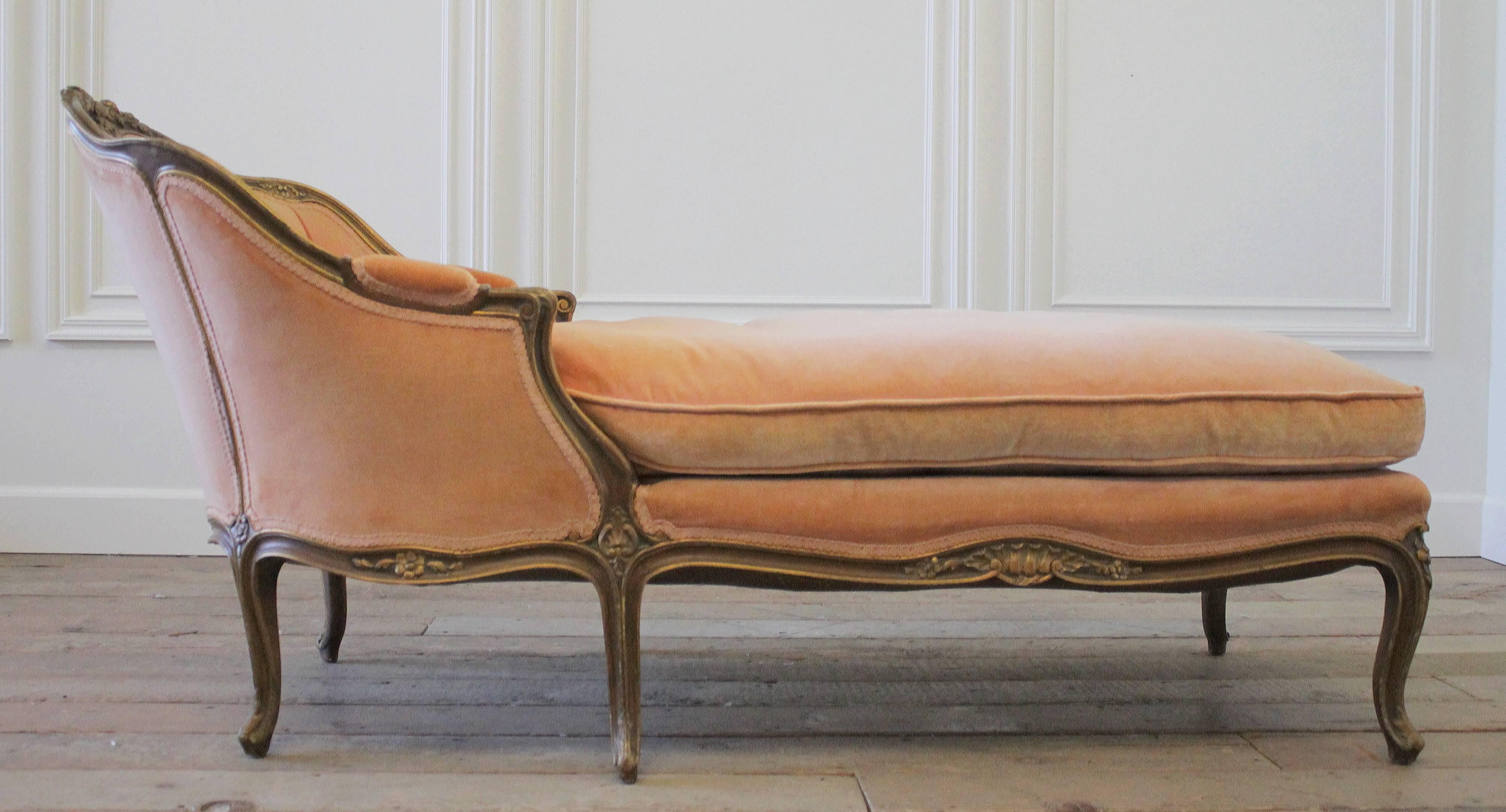 This gorgeous chaise longue is upholstered in a soft pink-peach tonal velvet, with plump down cushion. The upholstery is in good condition, a few minor markings on the seat, no holes or tears, or major flaws. The beautiful carved wood frame is in a