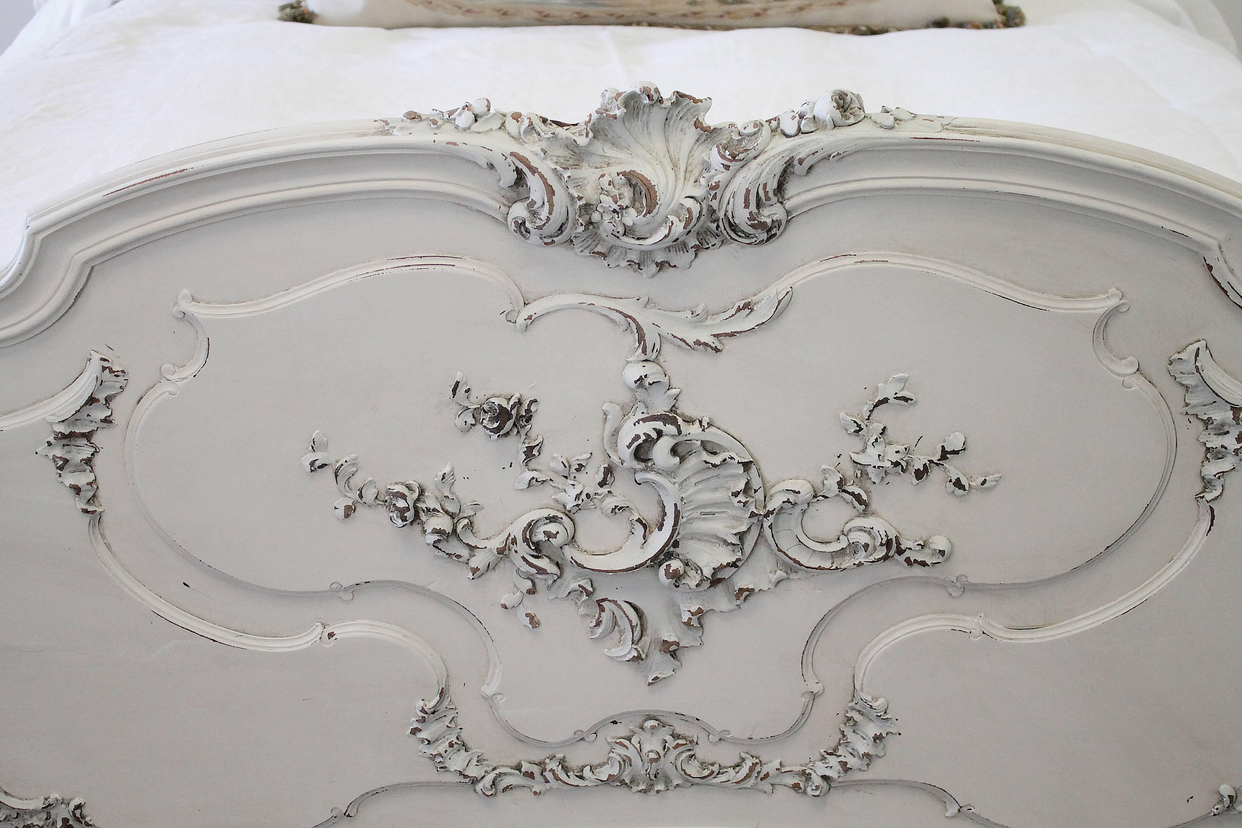 Gorgeous Louis XV style bed has been painted in our signature oyster white with hand-painted carved details in dover grey. The bed has subtle distressing, and is hand glazed to give an aged look of an original finish. 
This bed is solid carved