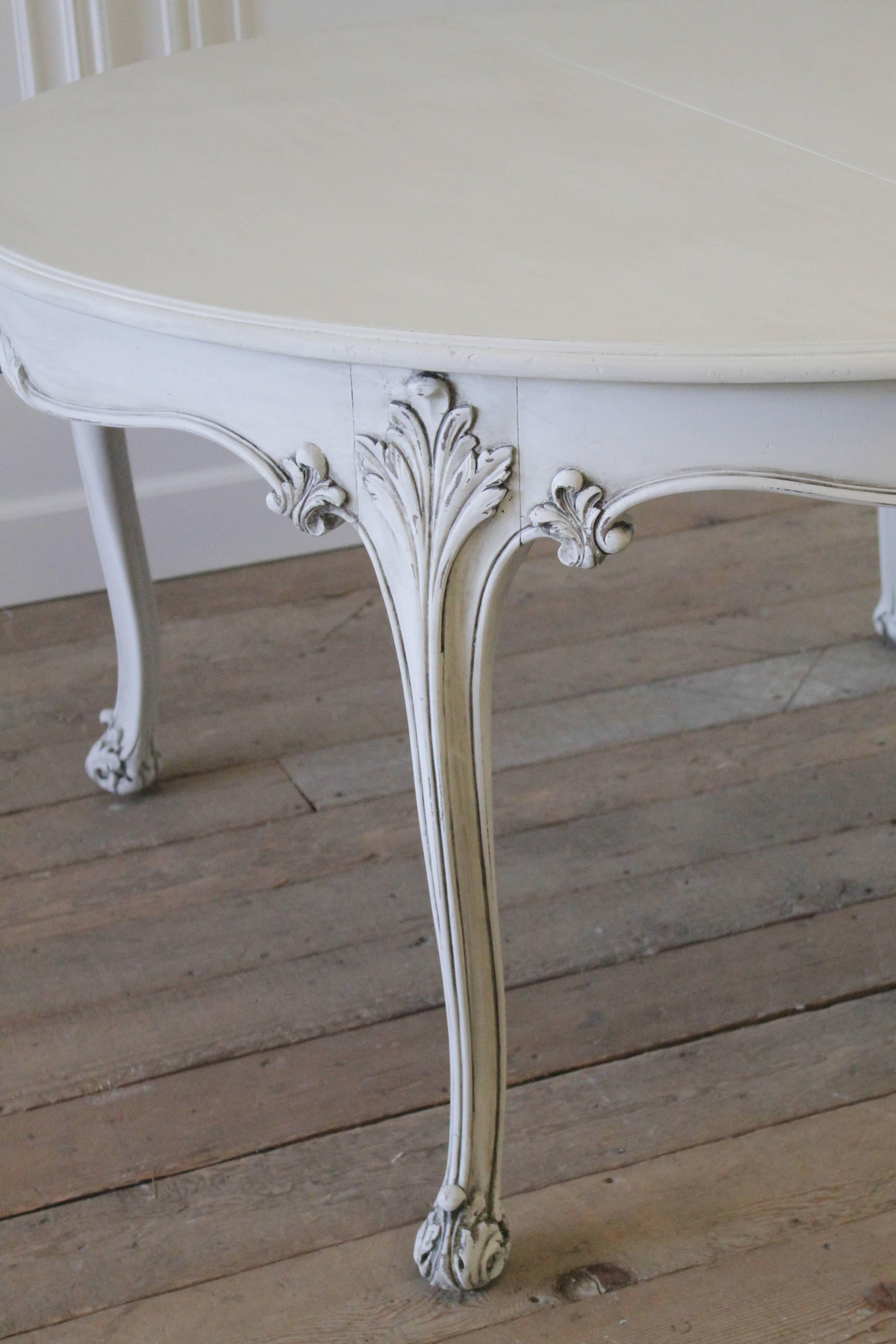 Beautiful round carved walnut dining table has two extension leaves. Painted in our oyster white with subtle distressing and an antique glaze finish.
I love the pretty carved cabriole style legs, with acanthus covered feet, and carved cartouche and