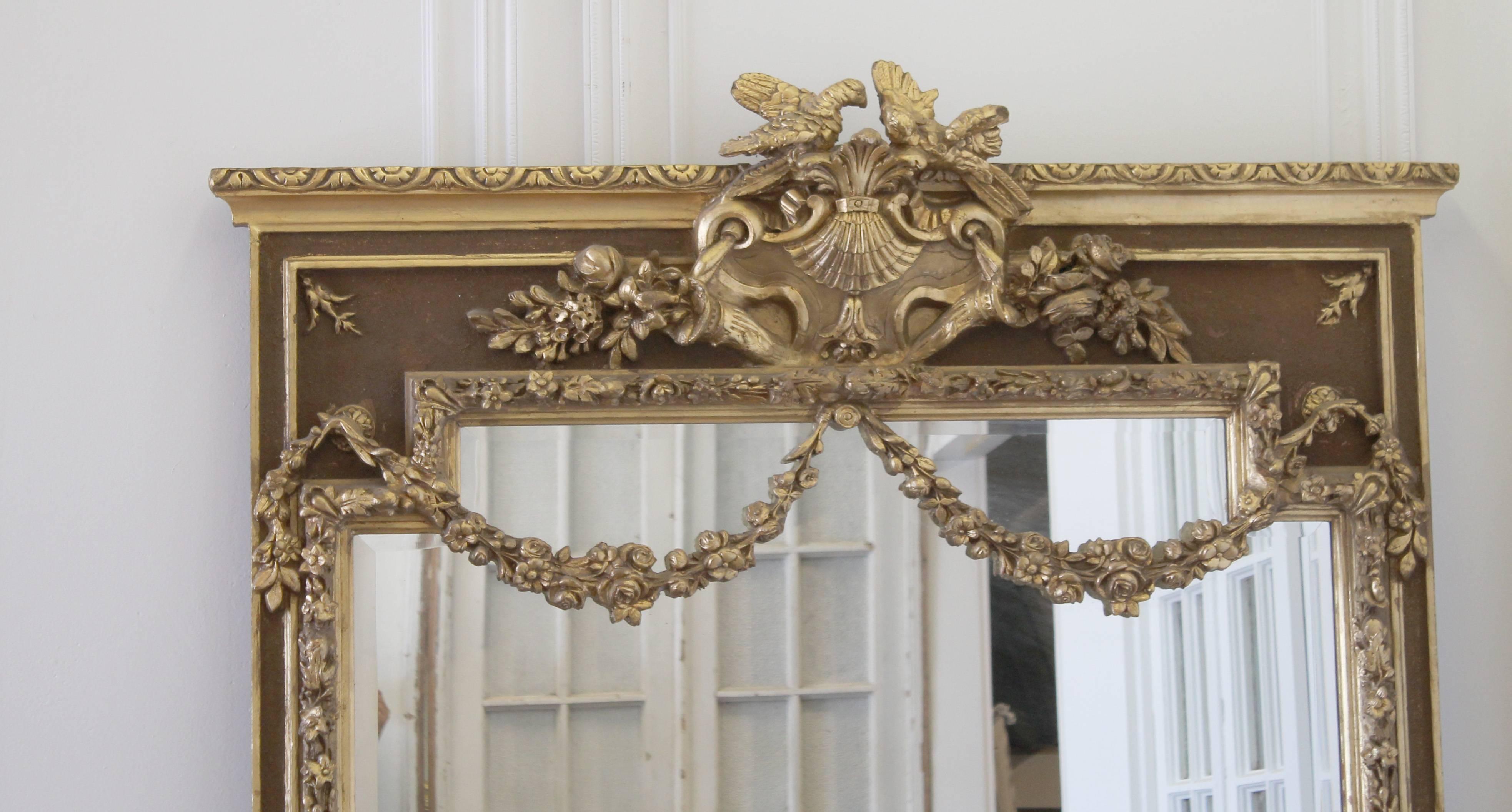 Fabulous wall mirror with carved roses and dove details. Finished in a bronze, and gilt with subtle patina. Beautiful large rose swags down over the top of the mirror, with trailing floral vines cascading down each side.
Wood and gesso carvings,