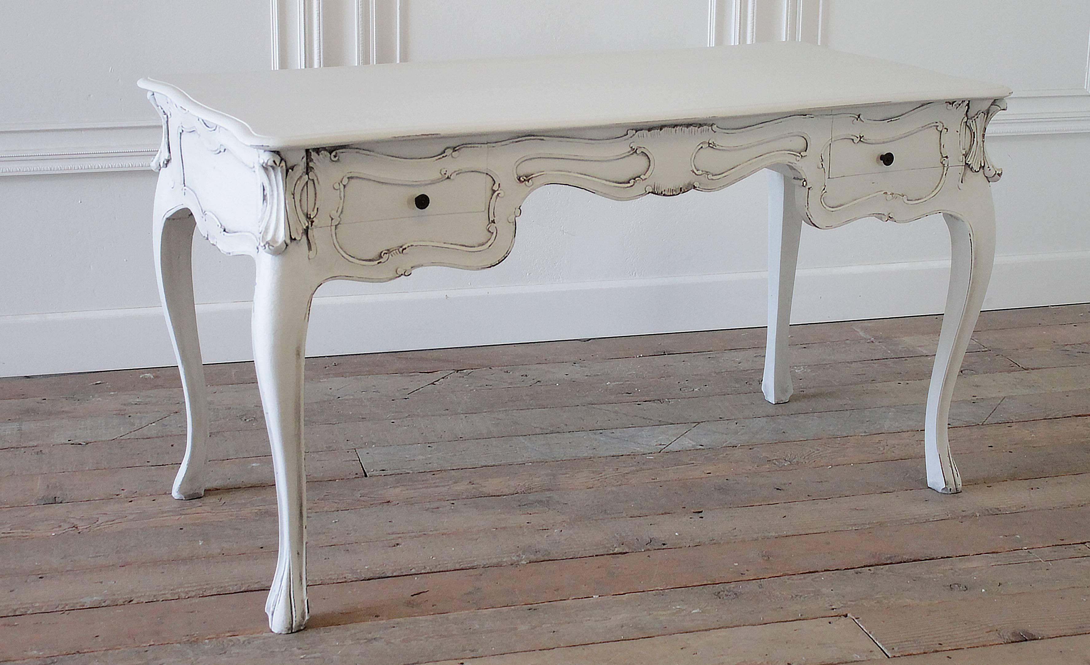 Beautiful Louis XV style bureau plat with two drawers. Perfect desk for your office, or use as a vanity. Painted in a soft oyster white with a subtle distressed and antique glaze finish. This gives the look of a beautiful aged finish. The two