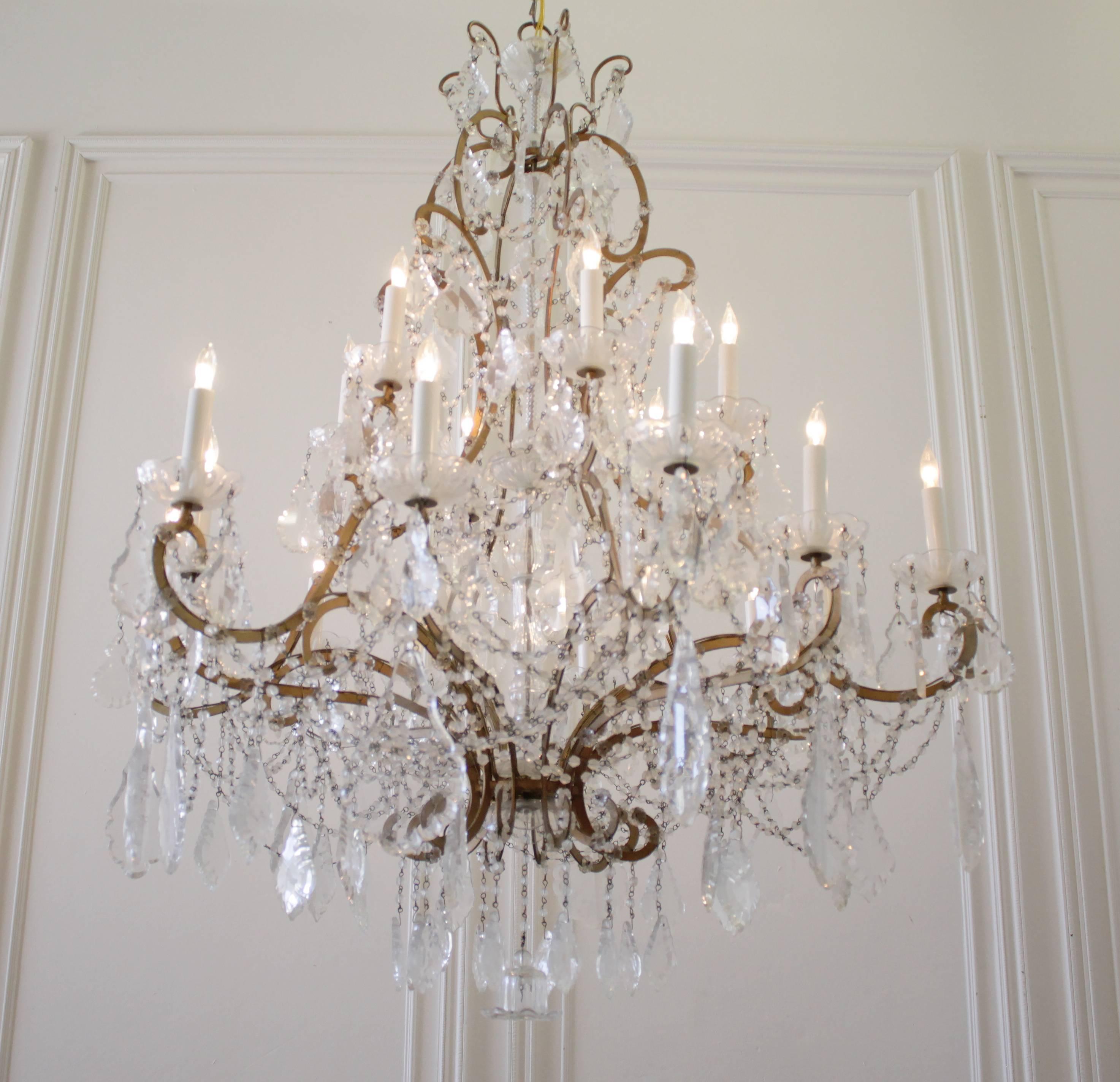 Impressive large Italian chandelier with two-tier of lights, 18 in total. Beautiful patina bronze frame with round cut crystal beaded strands and extra large French pendant crystals. Uses regular US chandelier light bulbs.
Measures: 39