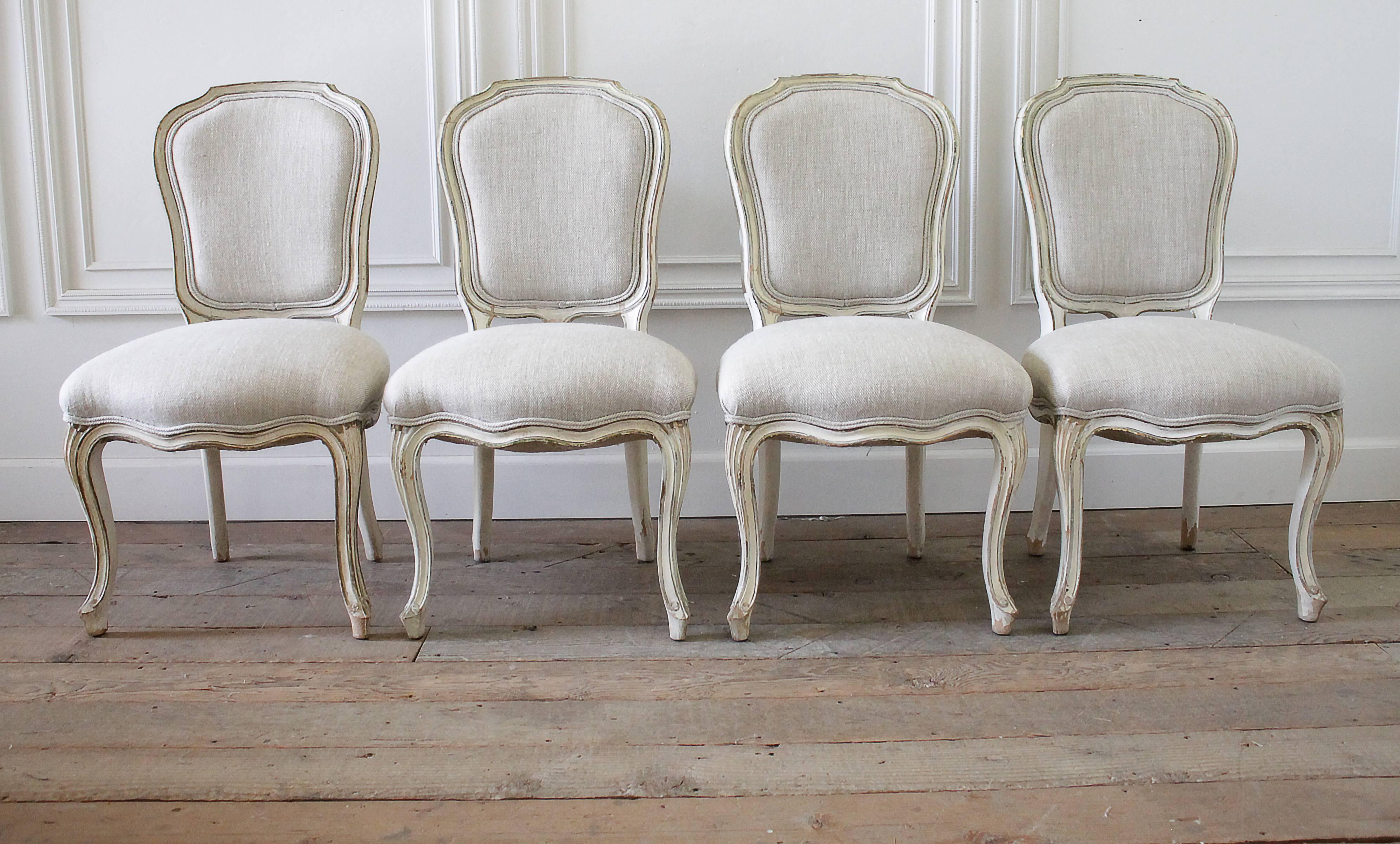 Fabulous set of painted dining chairs, circa 1940 has been upholstered in a light oatmeal Irish Linen. Finished with a burlap back, and double welt edge. The soft creamy color paint is original, and has the most wonderful chippy patina. The edge of
