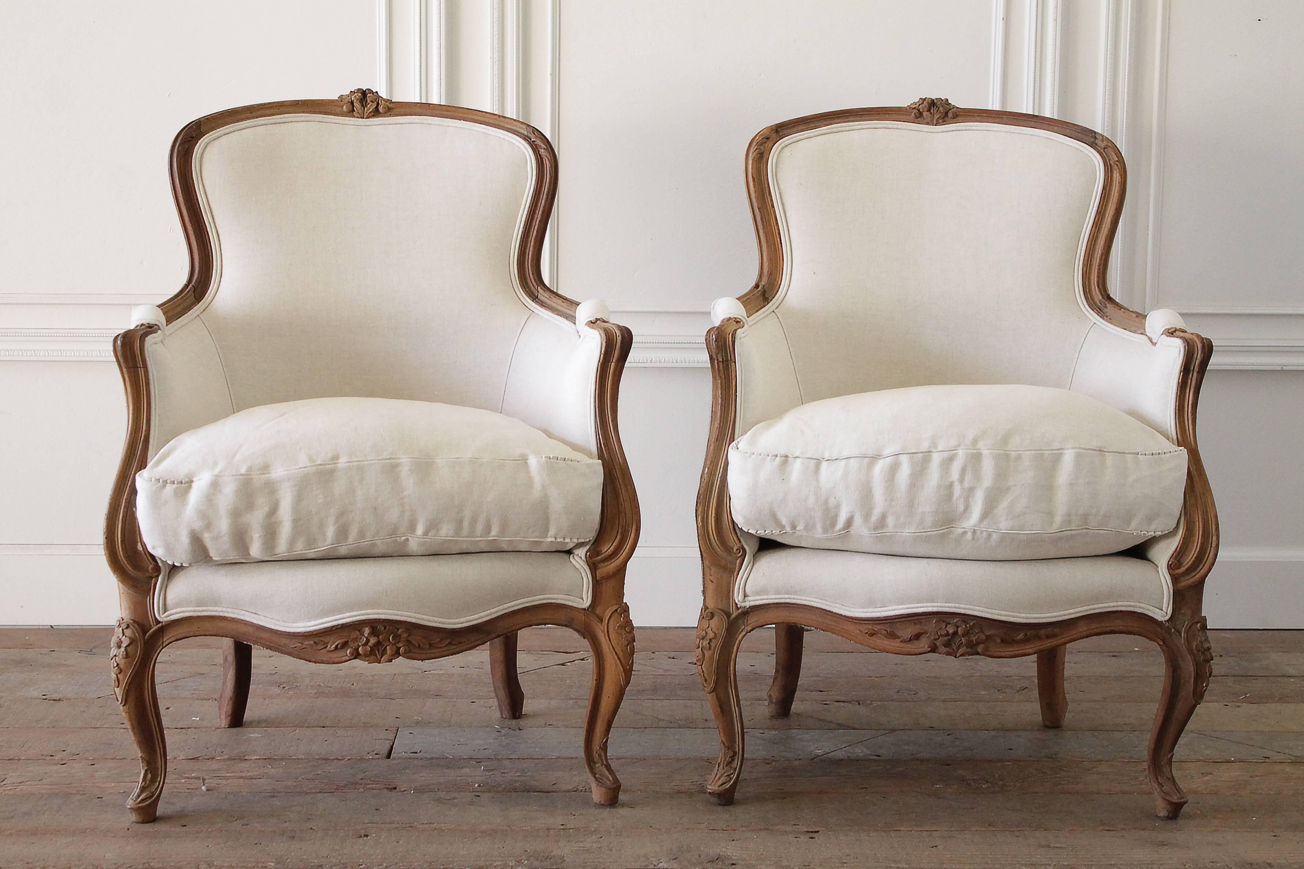 1 left, natural waxed finished carved bergere chairs. These chairs have been reupholstered in a soft light oatmeal colored Belgian linen. The seat cushions have a down cloud style cushion, with zipper closure and our 1/4" flange and pleated
