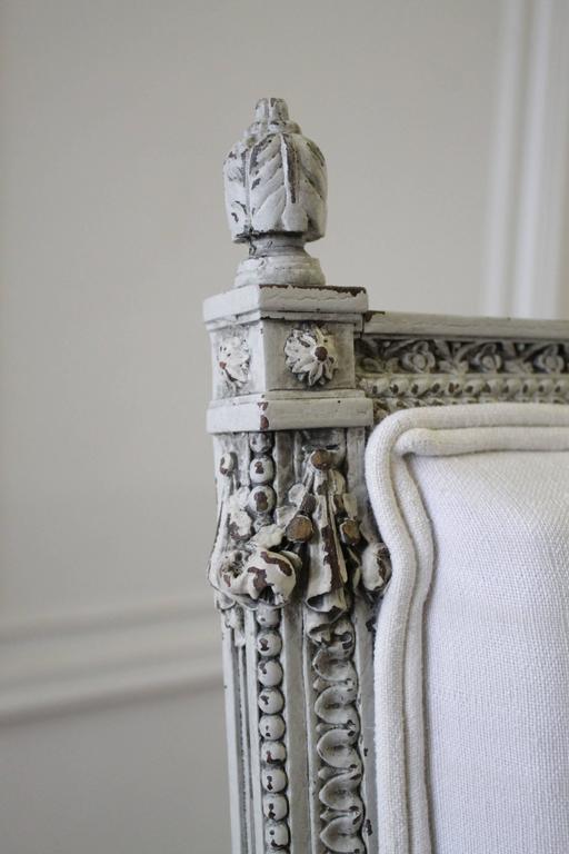 Beautiful pair of chairs with intricate carved rose swag details has been painted in our antique French grey wash, with subtle distress, and finished with our antique patina. Rose details are carved around each leg, with a twisted fluting, and