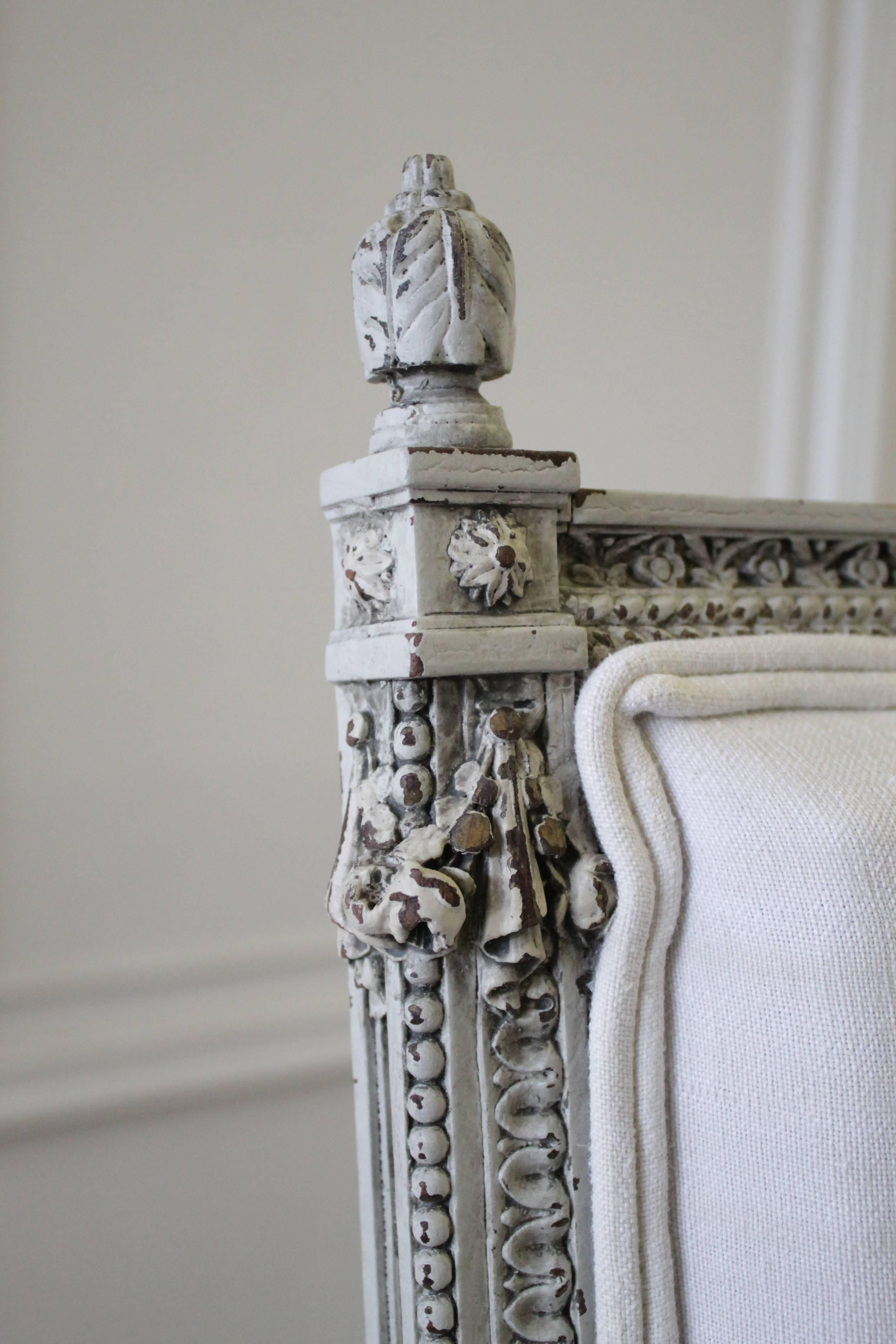 Beautiful pair of chairs with intricate carved rose swag details has been painted in our antique French grey wash, with subtle distress, and finished with our antique patina. Rose details are carved around each leg, with a twisted fluting, and