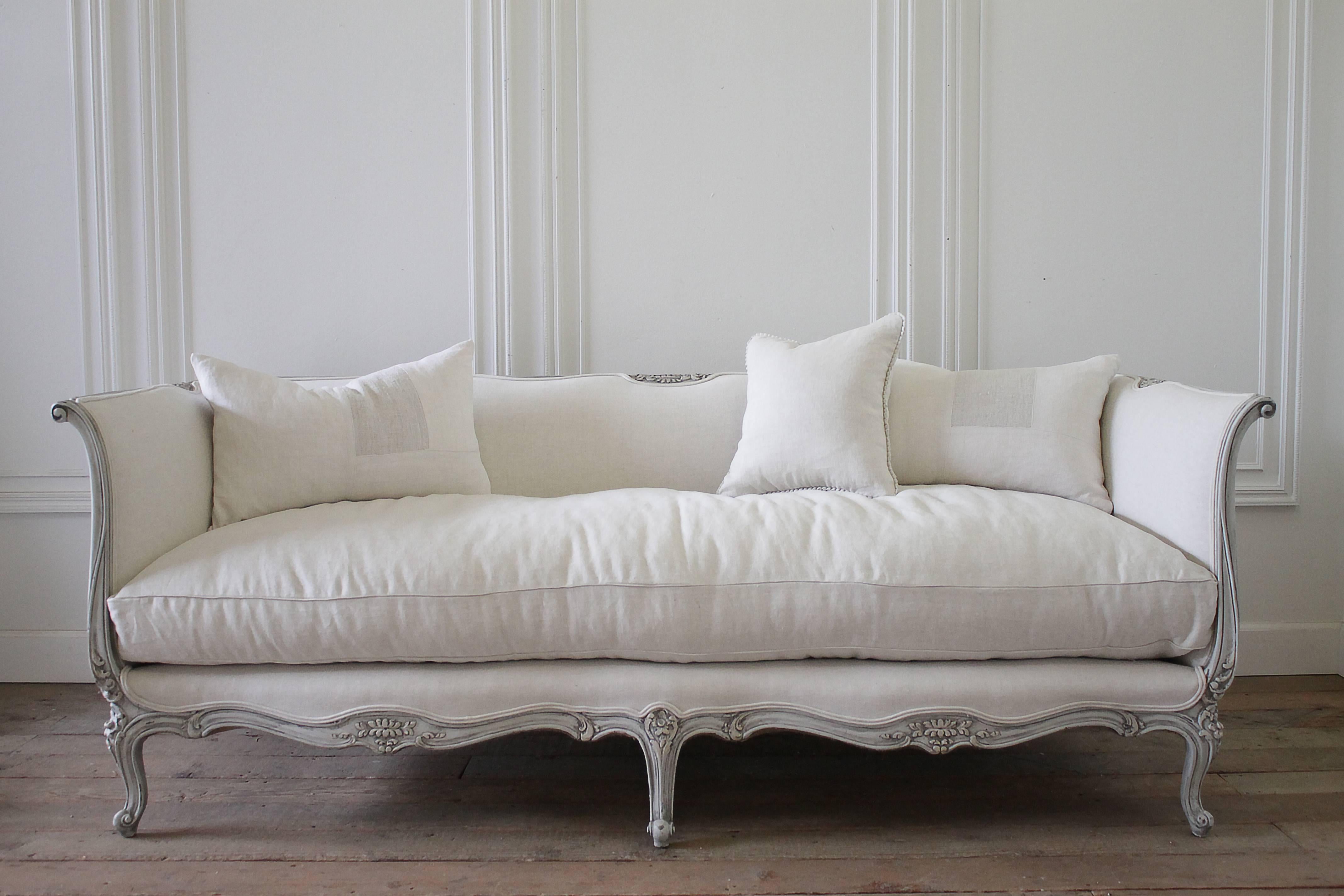 Lovely French Louis XV style sofa painted in our grain sack grey paint, and hand distressed aged patina. Classic cabriole carved legs with flower carvings. We reupholstered this sofa in a light oatmeal Belgian linen, and brand new plump cloud down
