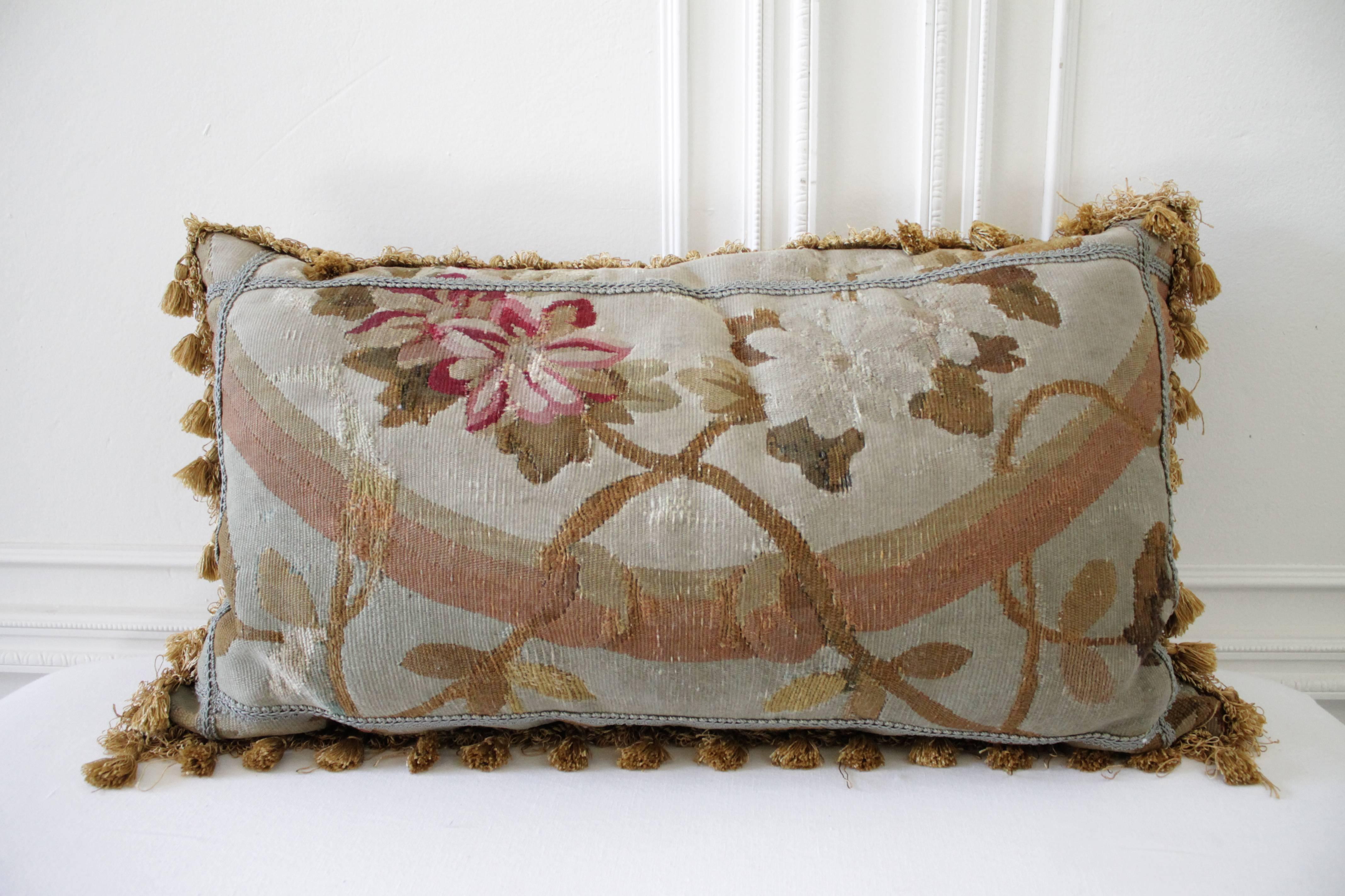 Gorgeous pair of antique pillows in a soft pale grey, tones of pale French blues, faded bronze, creams and red. Finished on the backside with a dark bronze brown velvet and trimmed with golden tassel.
Signs of age lightly faded on parts of the