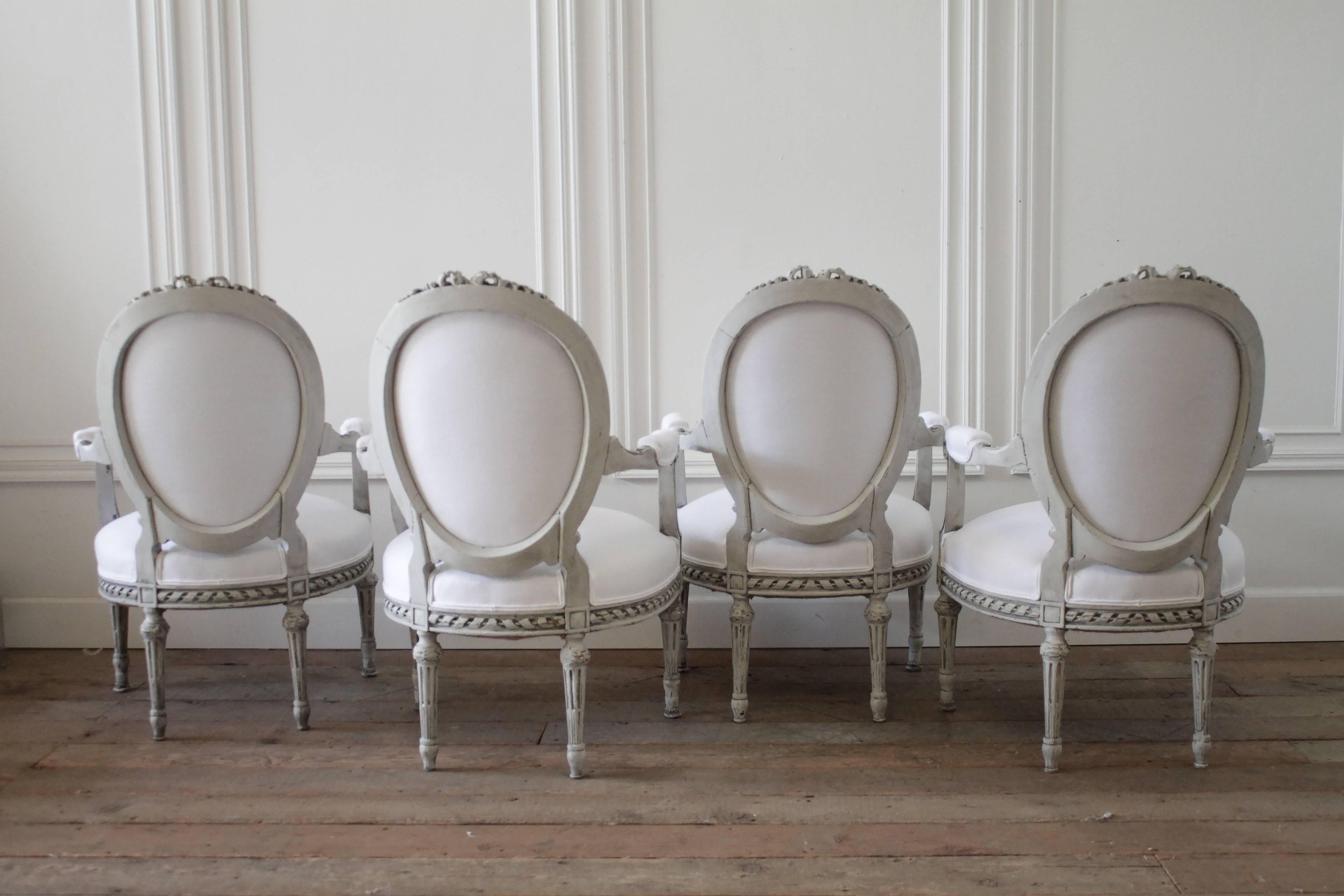 Four Painted and White Linen Upholstered Louis XVI Ribbon Carved Armchairs 3