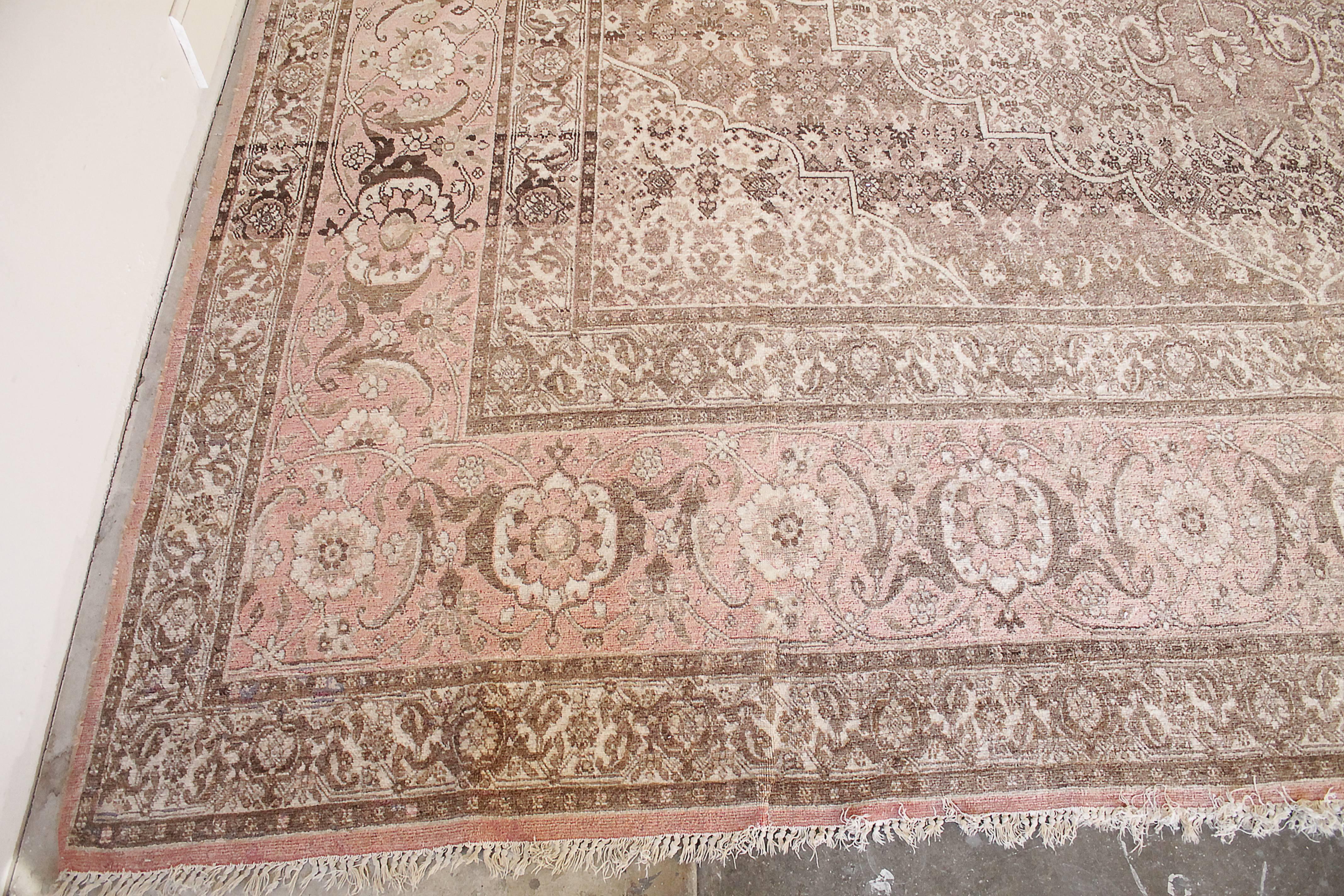 Schöne Vintage-Teppich, Farben sind verblasst rosa, creme, braun, mit Quaste endet. Die Quasten sind abgenutzt und einige länger als andere. Subtile Markierungen in den Fotos gezeigt, Bereich des Teppichs, wo es kleinere Verfärbungen sind. Es ist