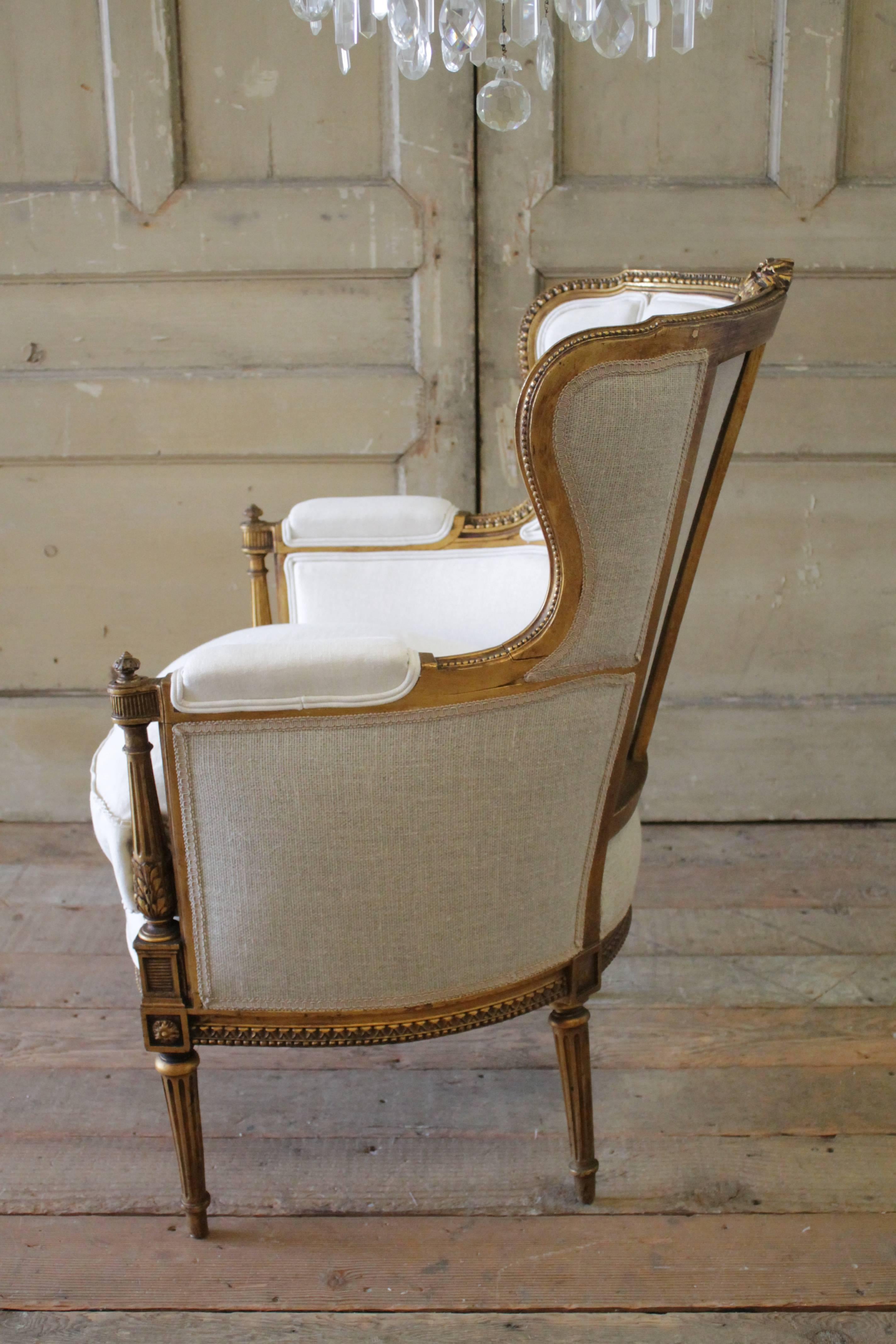 Carved Antique Louis XVI Style Gilt French Wing Chair with Linen Upholstery