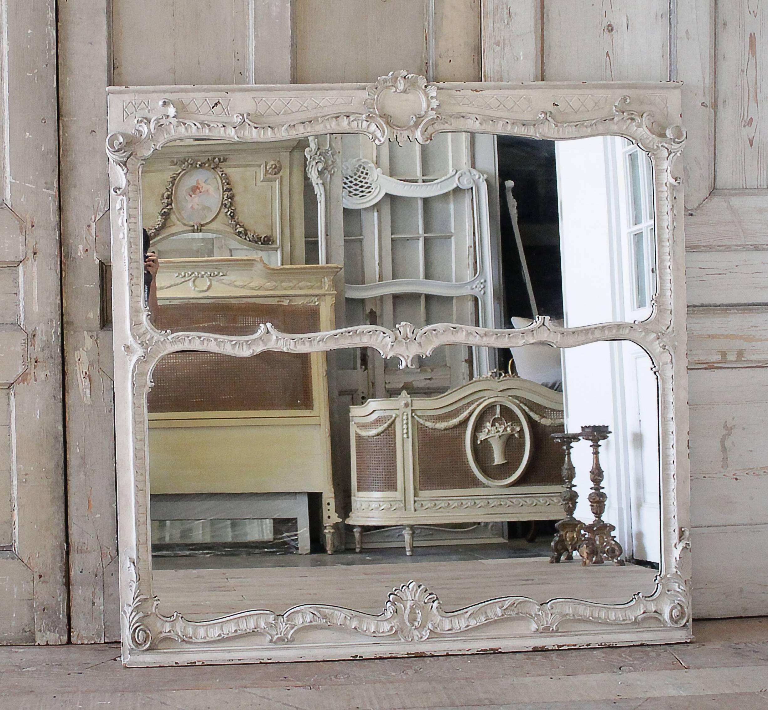 Beautiful large carved trumeau mirror with original painted finish. The paint looks to be a soft beige with a lighter tone of cream. The frame does have a distressed finish, with signs of wear, chippy paint, scratches, which only add to the beauty