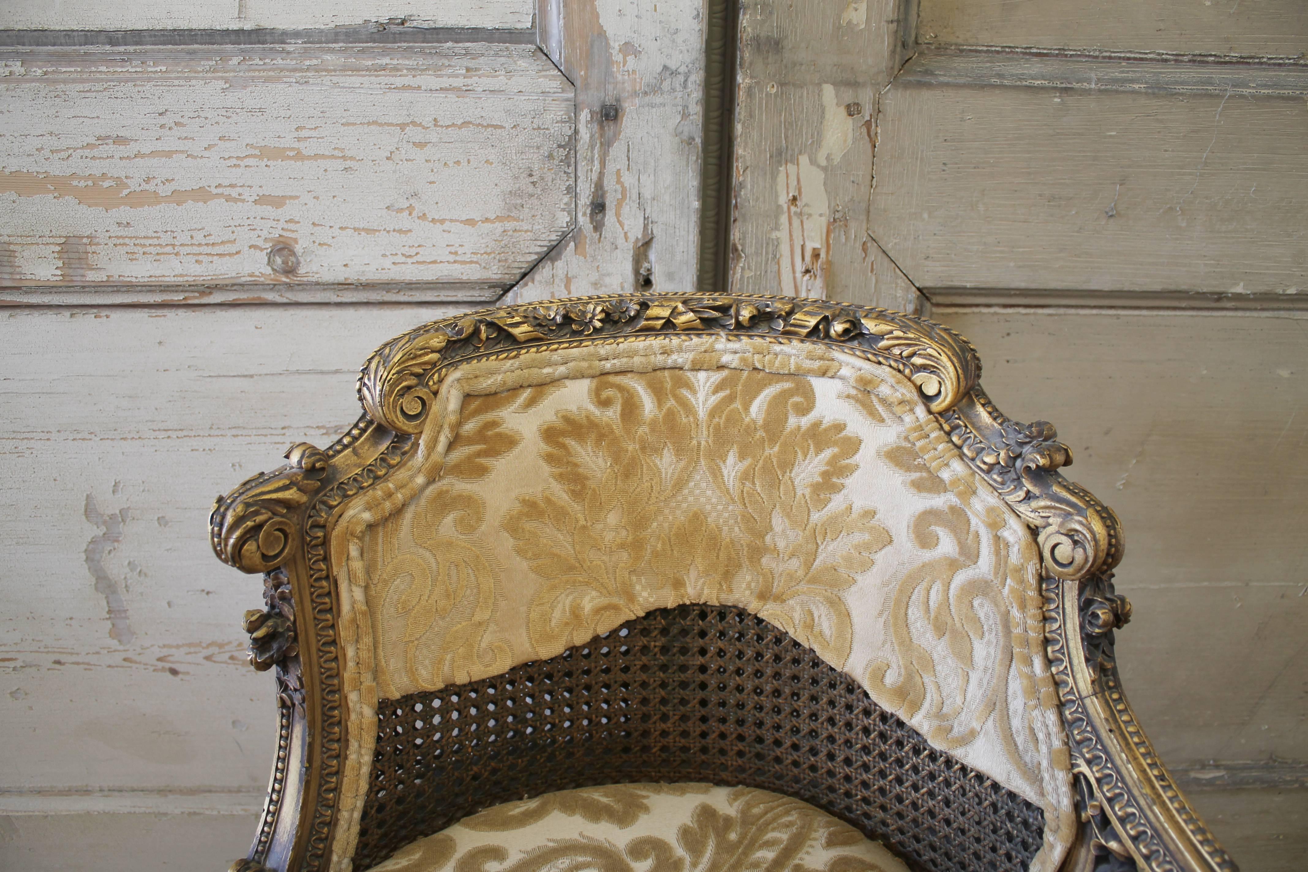 Fabulous giltwood chairs with intricate carved details. These low back carved Louis XVI style chairs are original double caned backs, and caned seats with a custom upholstered seat cushion that is removable. There are vines of detailed carved roses