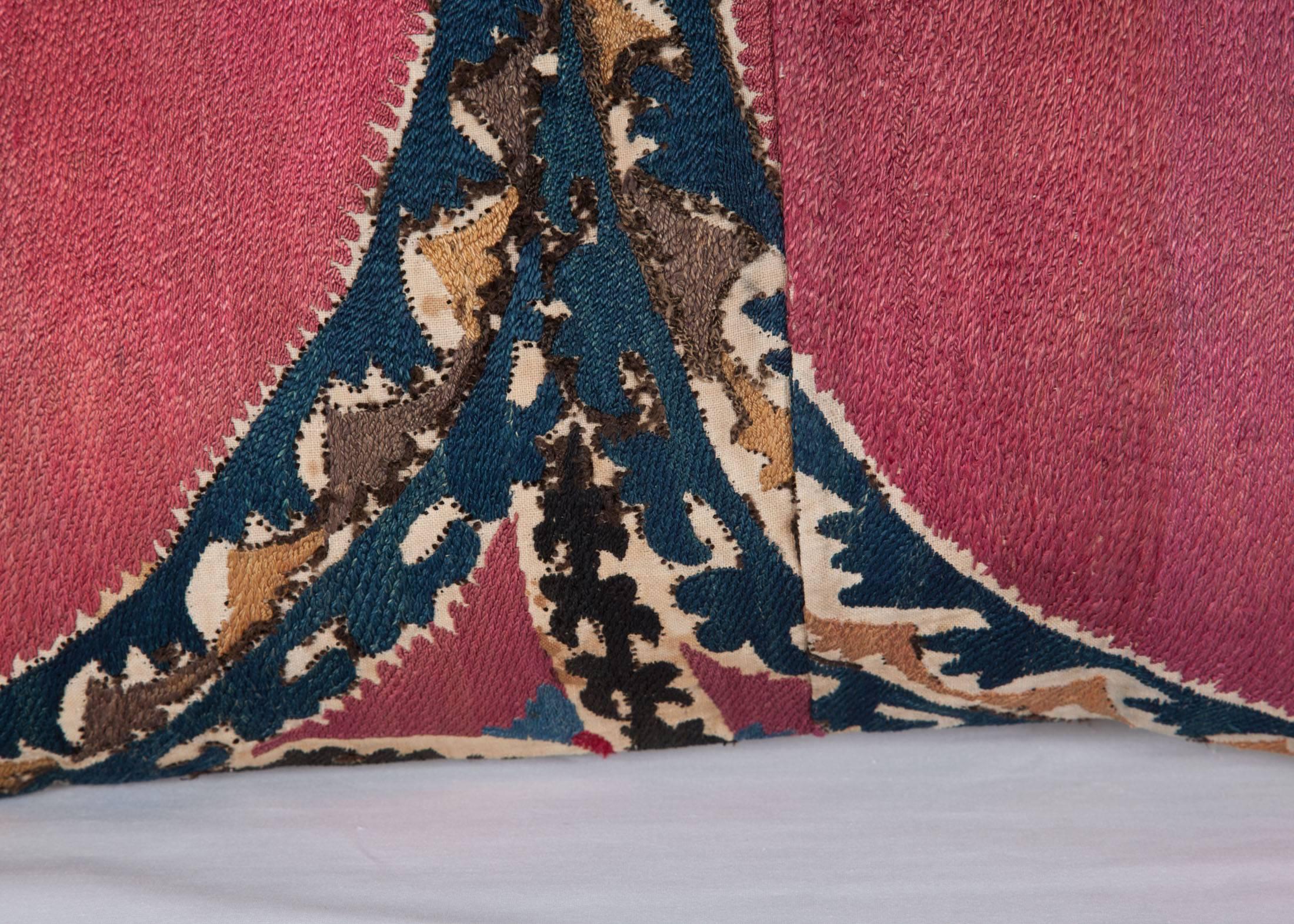 The pillow is made out of a 19th century Uzbek Tashkent Suzani. 
It does not come with an insert but it comes with a bag made to the size and out of cotton to accommodate the filling.
The backing is made of linen.

Please note filling is not
