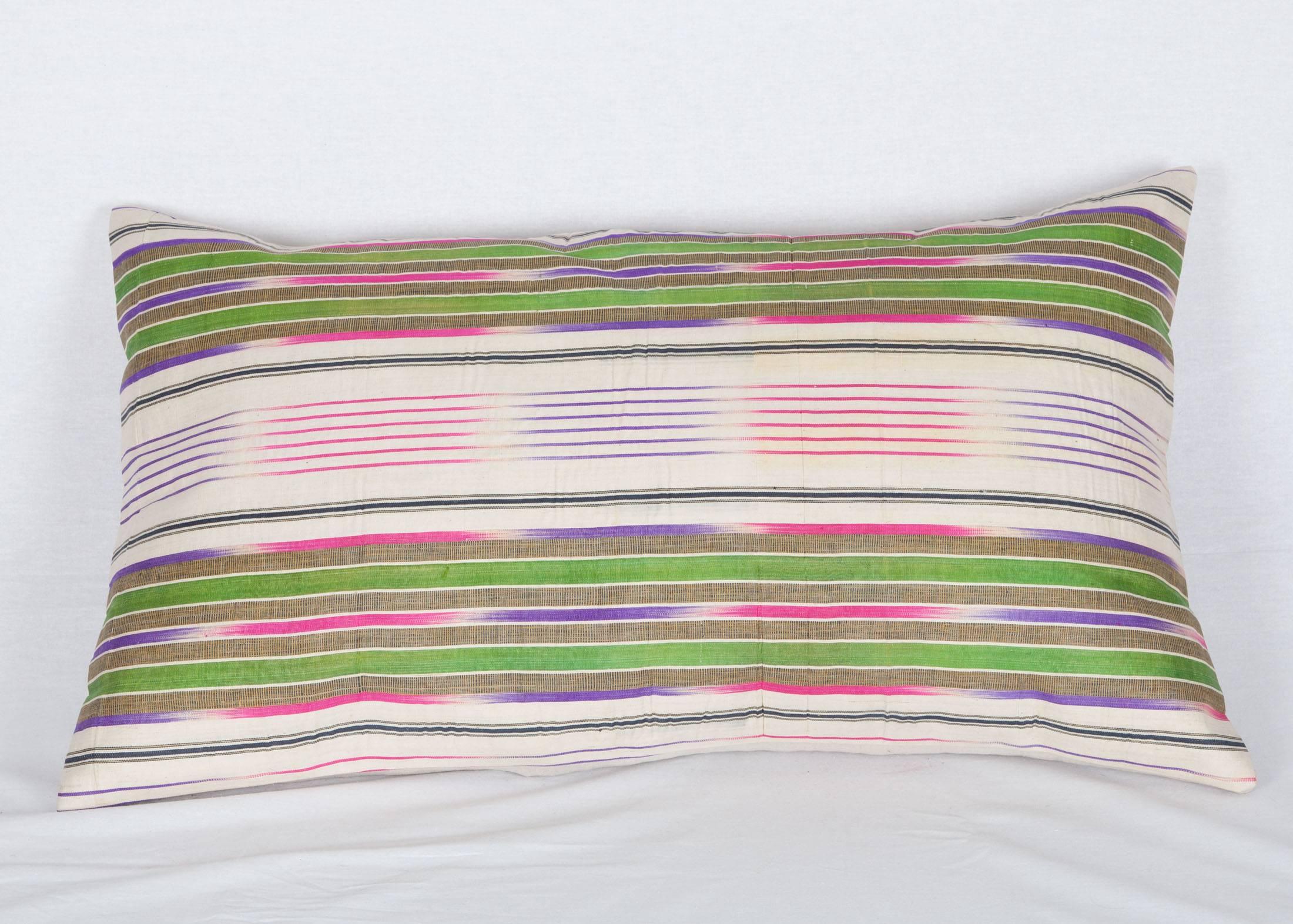 The pillow is made out of a early 20th century silk warp, cotton weft Ikat fabric.
It does not come with an insert but it comes with a bag made to the size and out of cotton to accommodate the filling.
The backing is made of linen.

Please note
