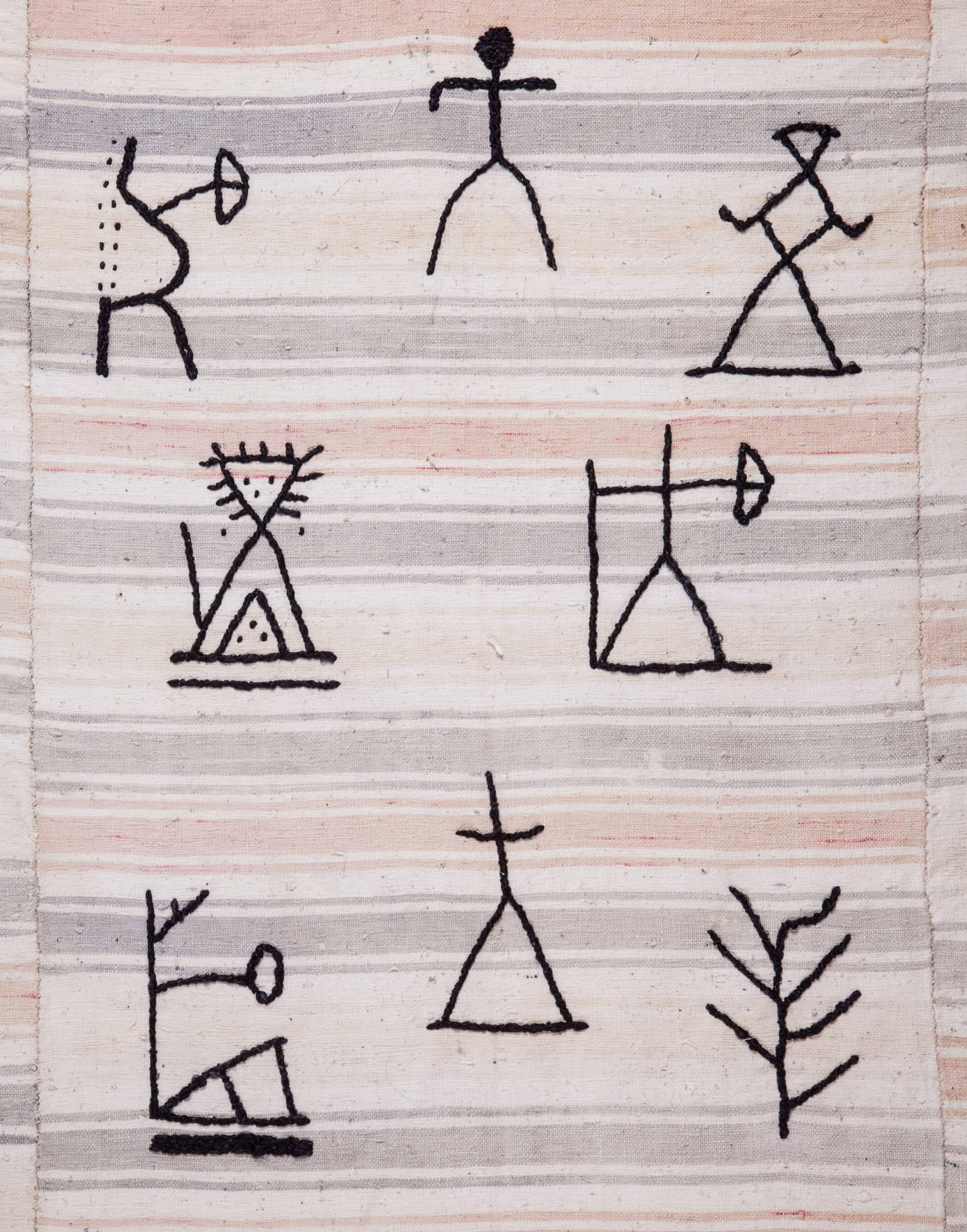 Ich war schon immer von Petroglyphen und Schamanenbildern fasziniert und habe Designelemente von Schamanentrommeln und Felsritzungen gesammelt. Ich habe eine Gruppe von Stickerinnen zusammengetrommelt und die Entwürfe auf schwarze Seide gestickt,