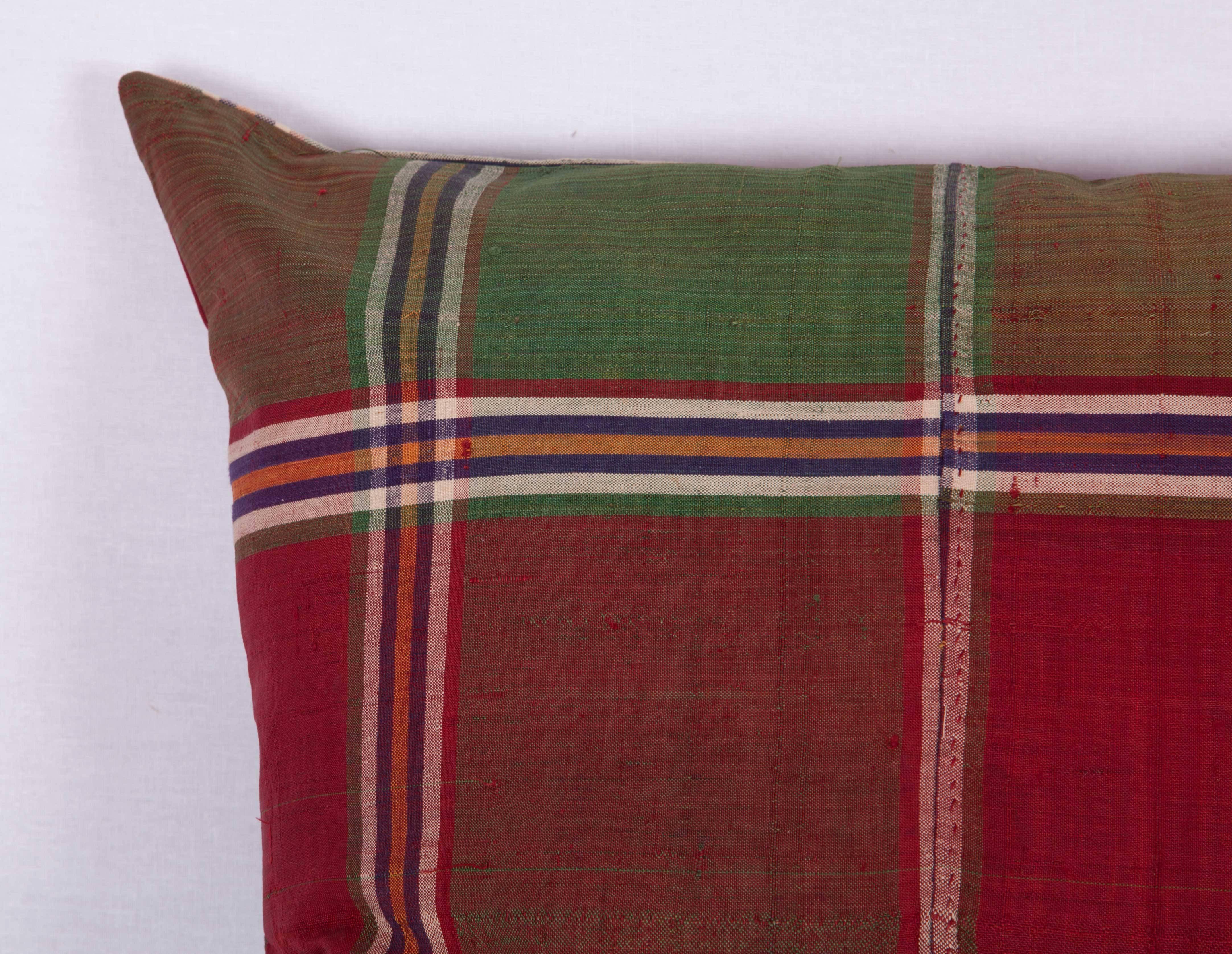 L'oreiller est fabriqué à partir d'un châle en soie turkmène du milieu du XXe siècle. Il n'est pas livré avec un insert mais avec un sac fait à la taille et en coton pour accueillir la garniture. Le support est fabriqué dans le même tissu. Veuillez
