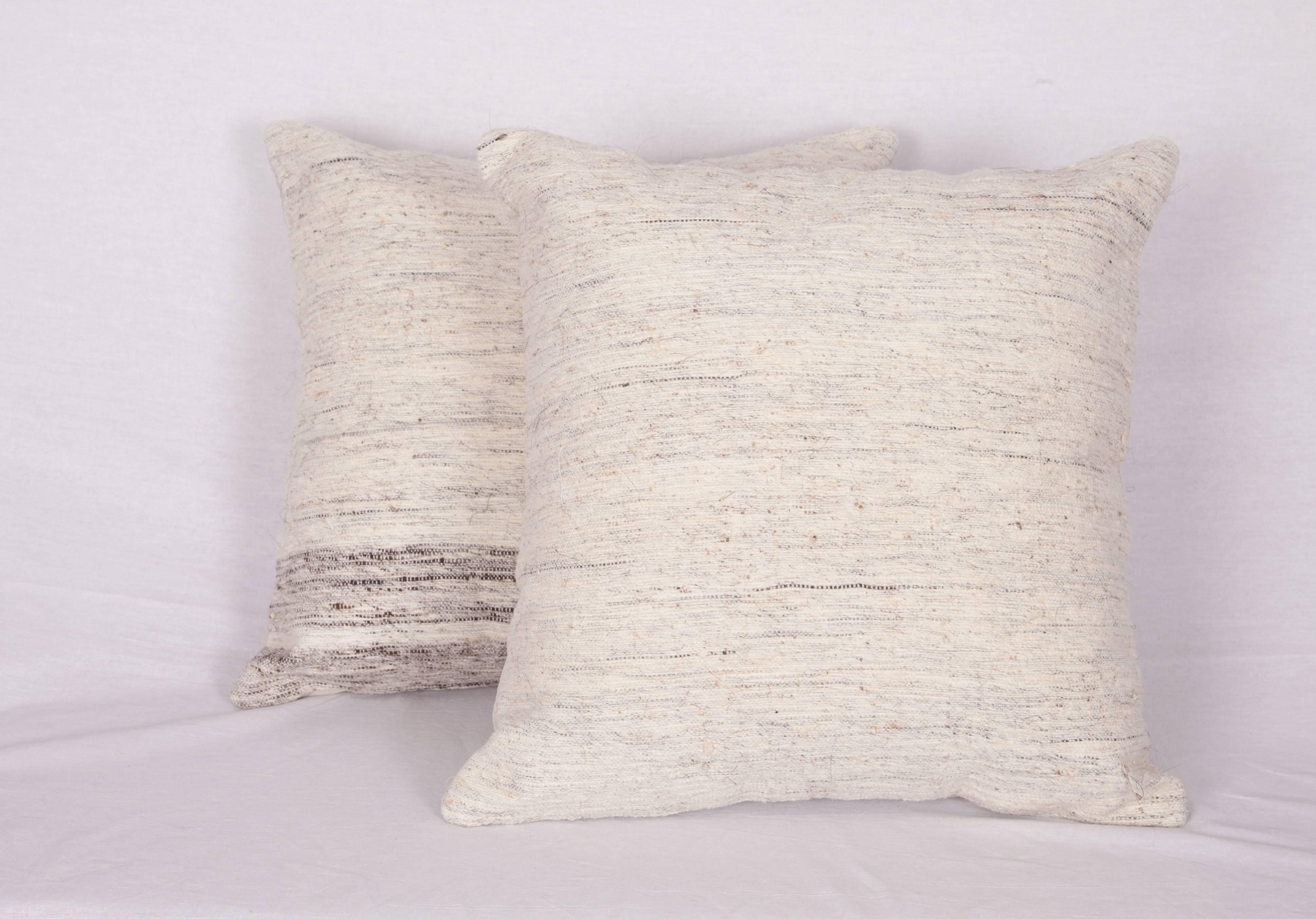 The pillows are made out of mid-20th century cotton and goat hair Kilim. They do not come with an insert but they come with a bag made to the size and out of cotton to accommodate the filling. The backing is made of linen. Please note filling is not
