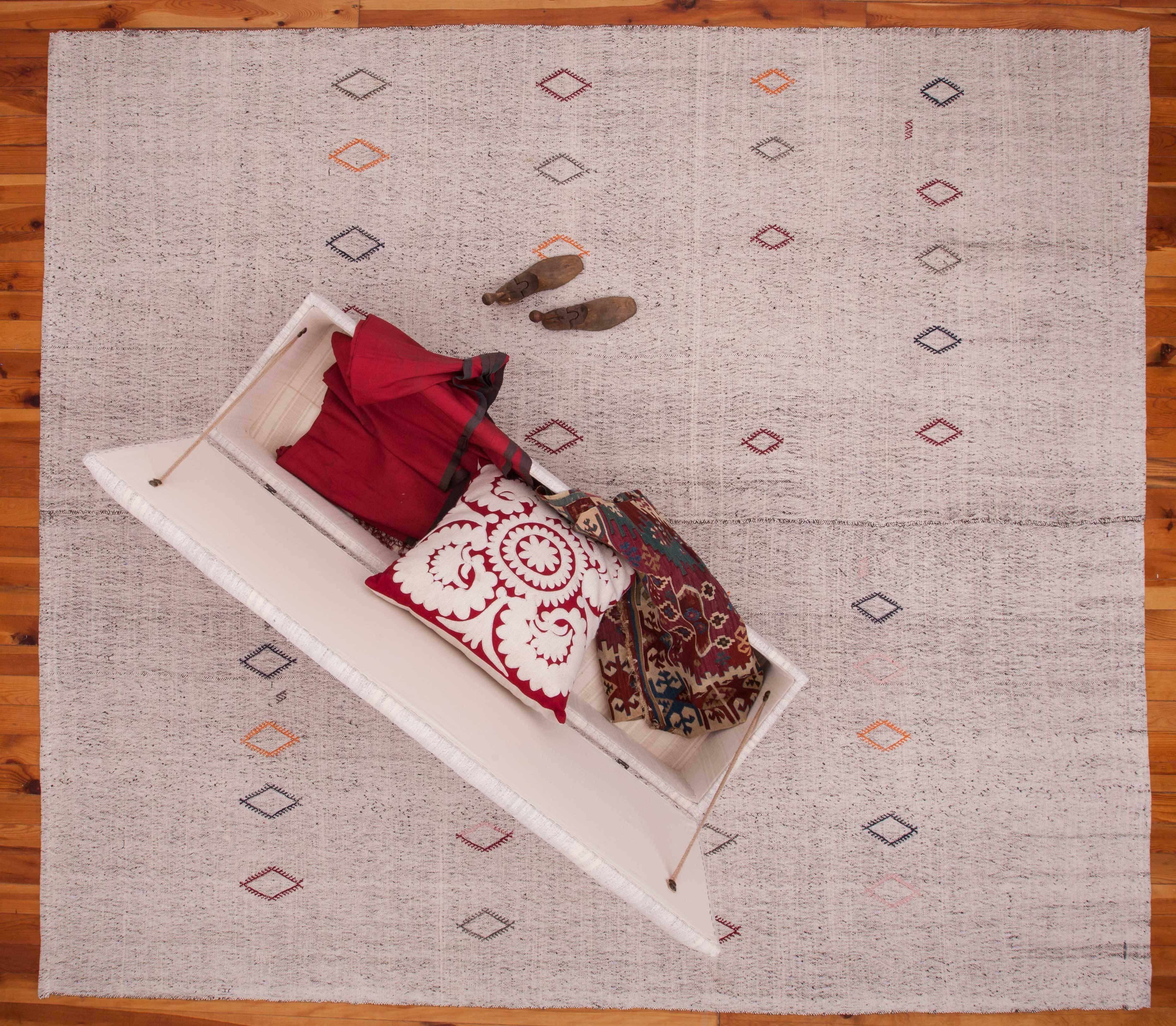 The warp threads on the kilim are from goat hair and the weft is cotton and the combination results in a salt and peppr look. Decoraded with embroidered jicims.