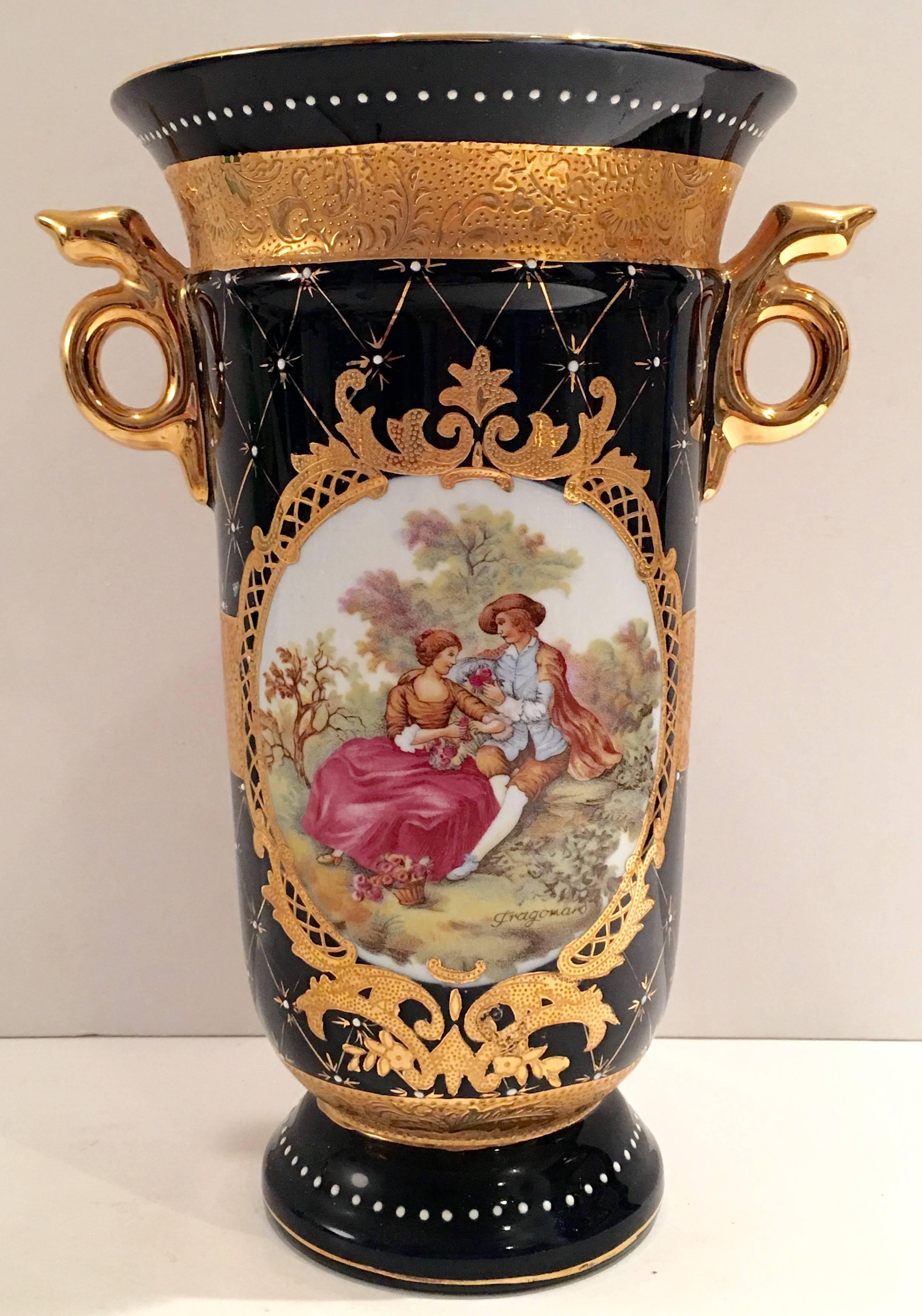 Limoges, P.R.C French Sevres style vase hand-painted in cobalt with 22-karat gold detail. Featuring a central 17th century courting couple motif and gold snake form handles. Signed on the underside, L.F. Limoges P.R.C. Handcrafted.