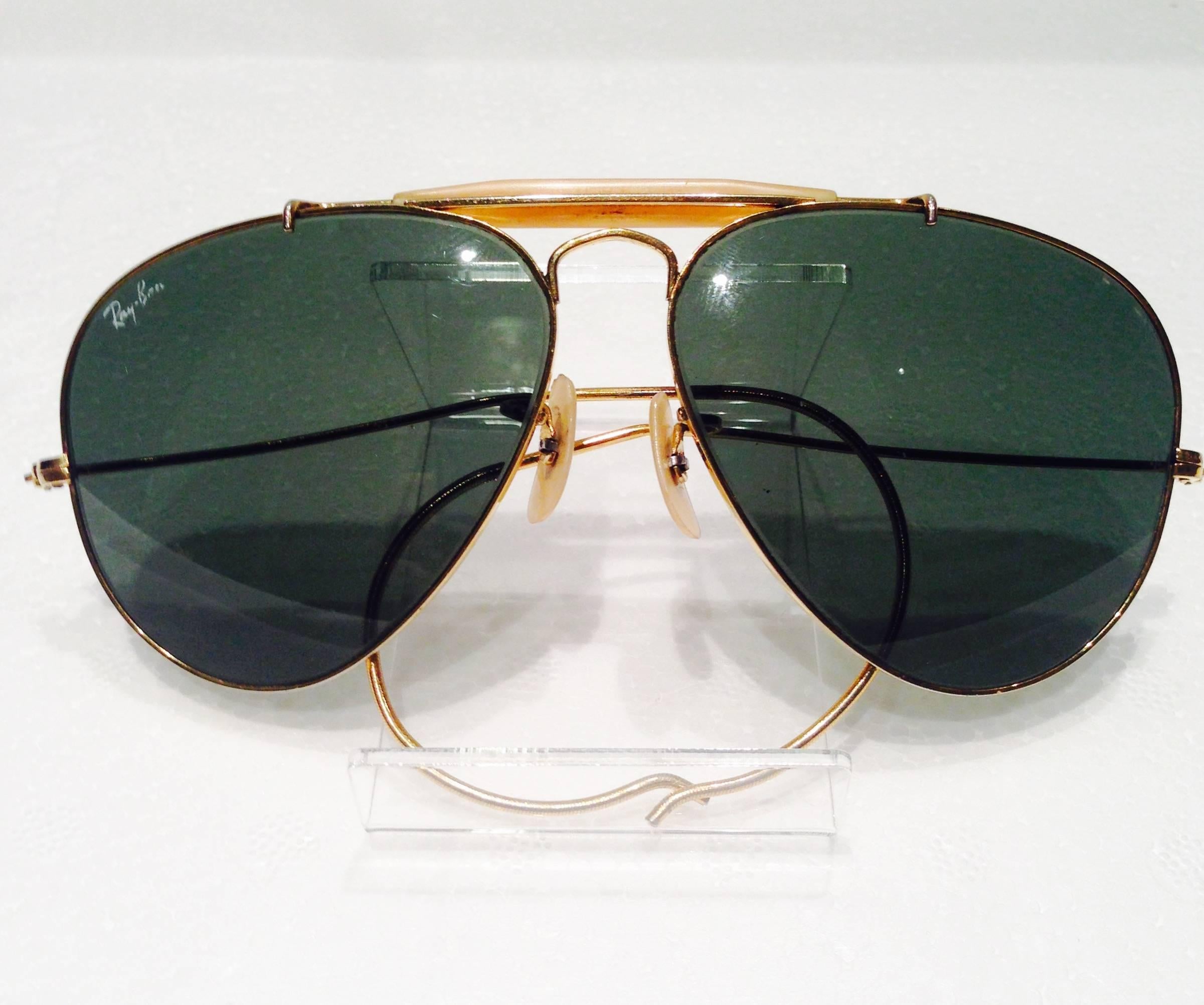 Rare 1960s Ray Ban by Bausch & Lomb gold plate with dark green UV protection lenses and the Ray Ban logo appearing on the upper left of the left lens. The dark green lenses are impact resistant glass. These Classic aviator 