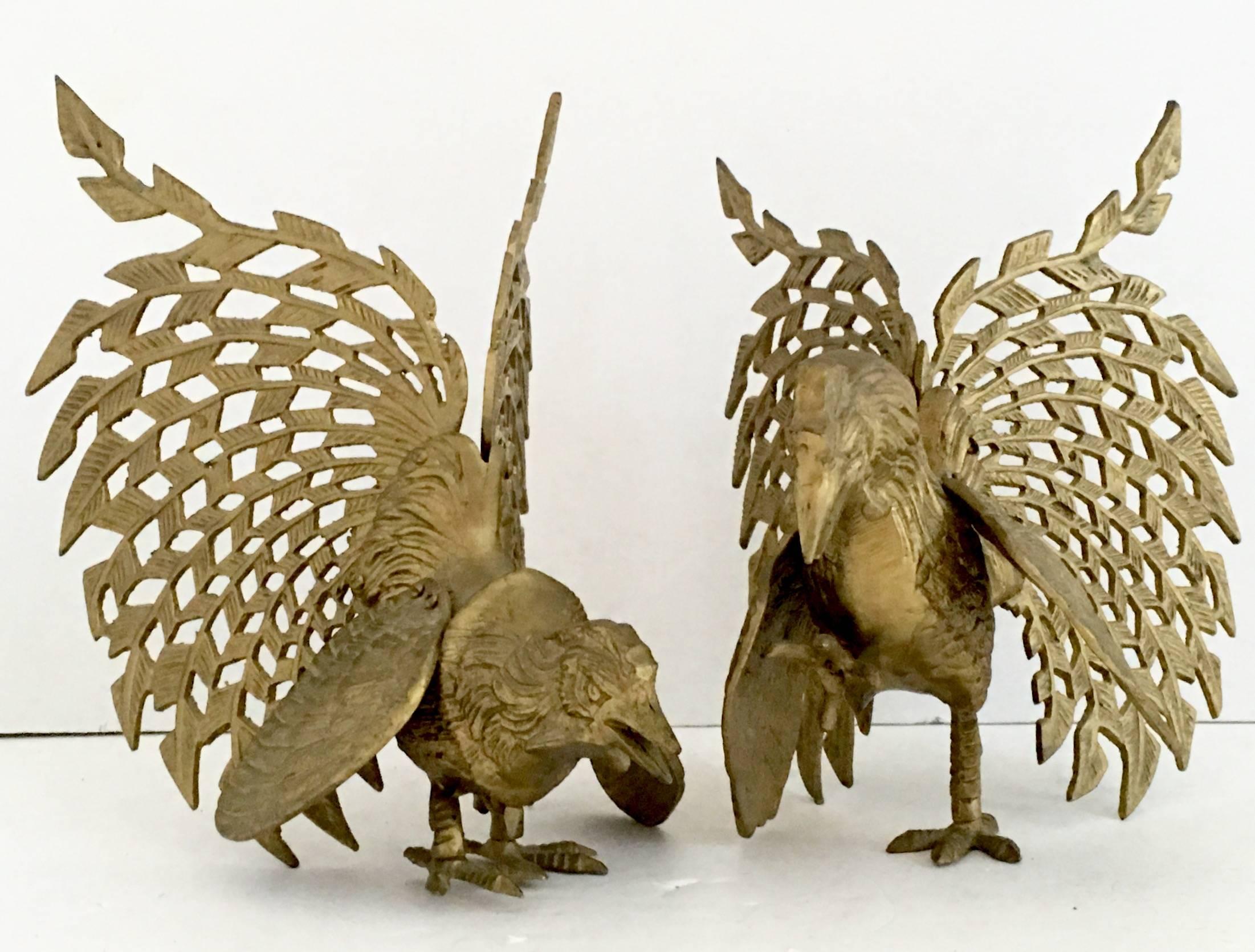Italian pair of Mid-Century solid brass rooster sculptures in fighting pose.Each rooster features coveted large fan style cut out tail in motion with adjustable wings.