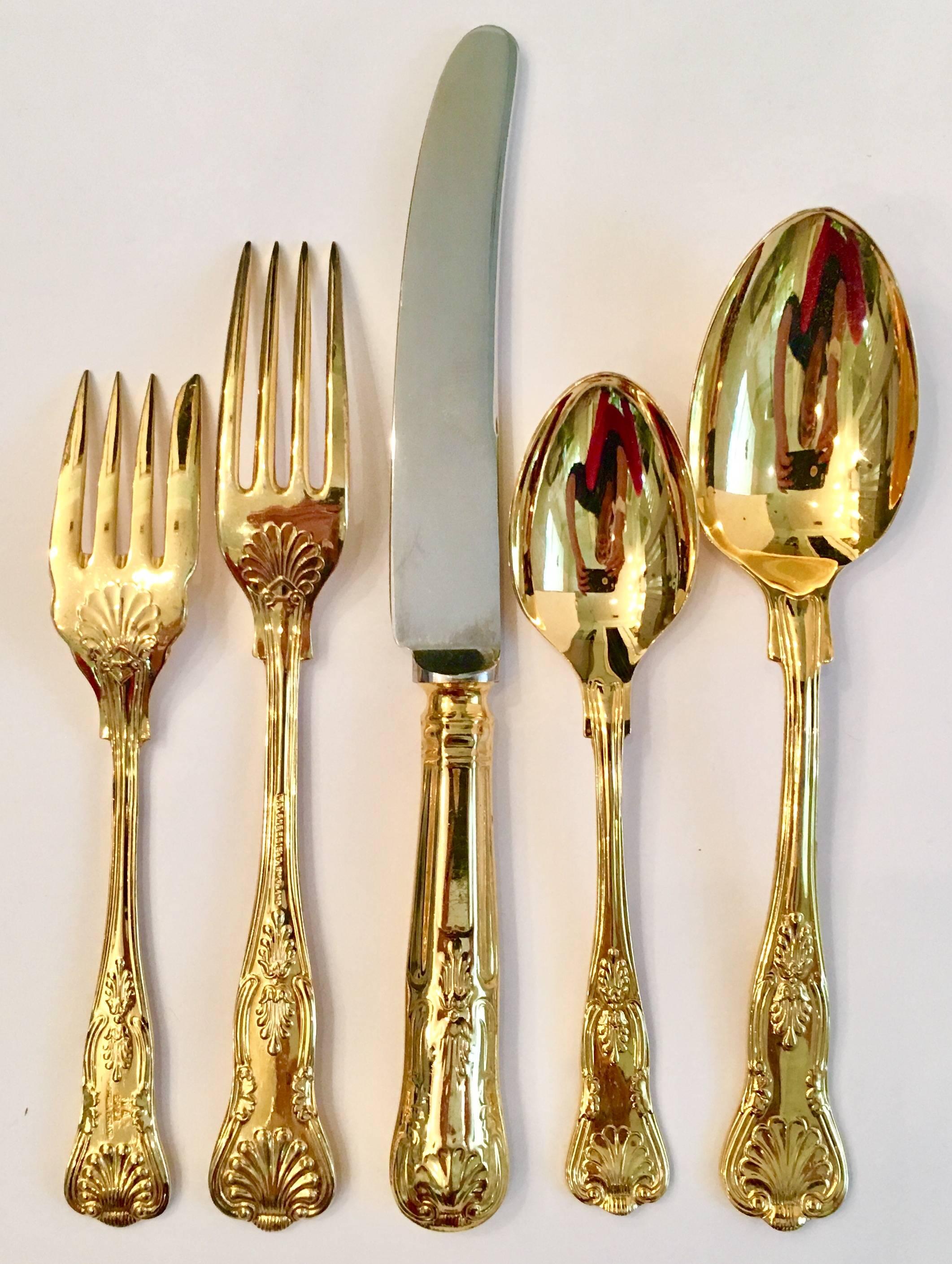 Sheffield England gold wash silver plate 55-piece flatware set in a scallop shell motif by, William Adams. Set includes eight, five-piece place settings, eight additional teaspoons and two serving spoons. Knife blade is stainless steel. Each piece