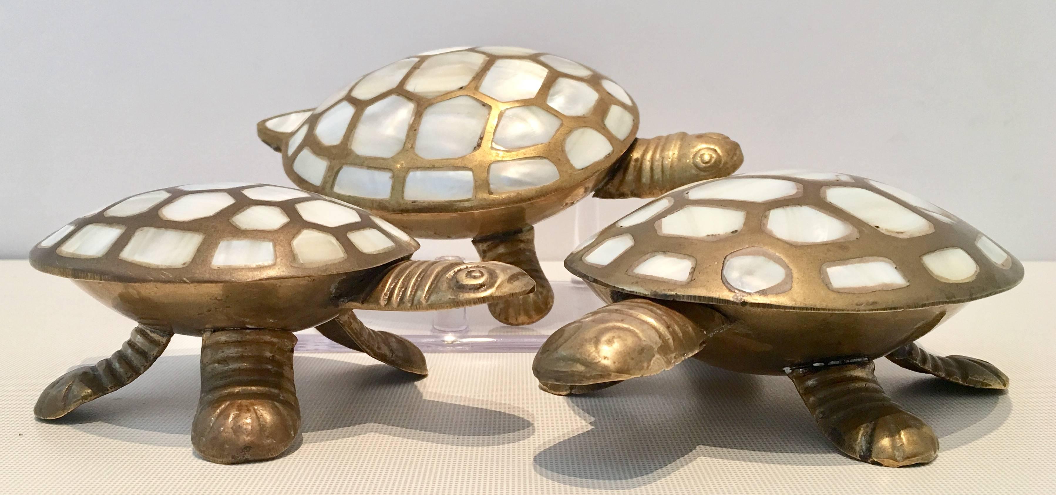 Adorable and rare set of three hinged turtle boxes made of solid brass and mother of pearl inlay. Then medium sized turtle measures, 1.5