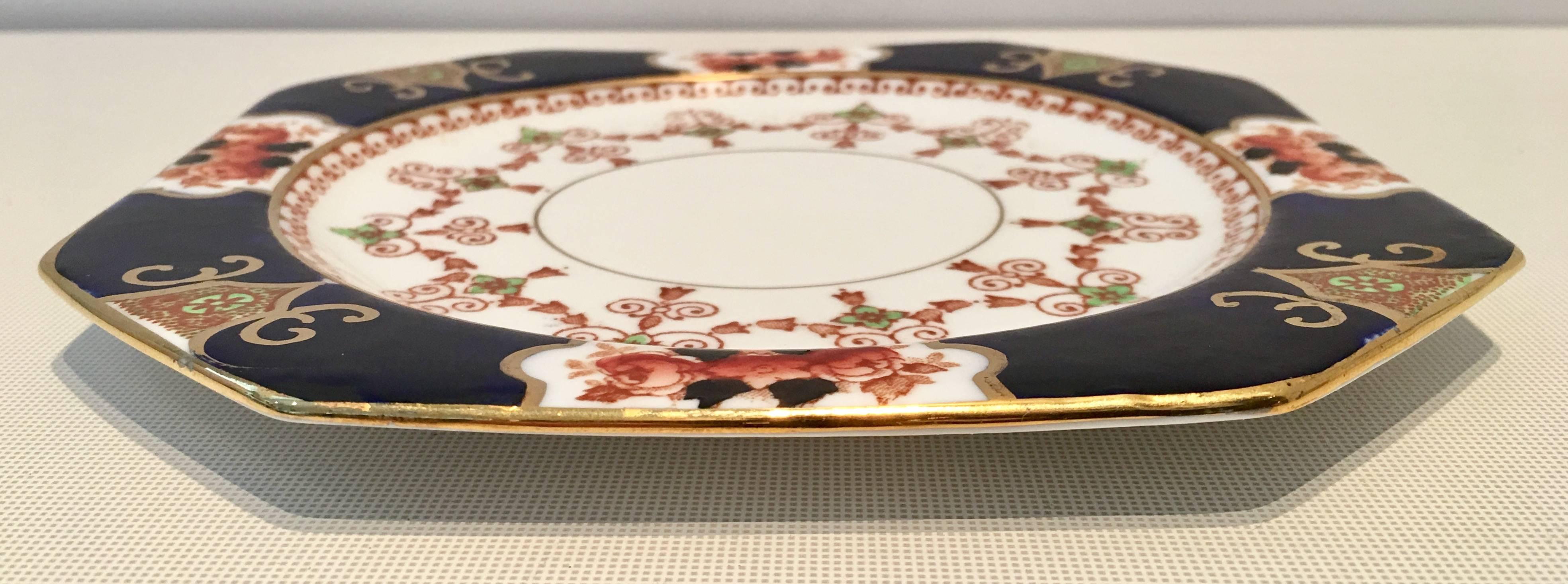 Rare hexagon shaped English royal Stafford bone china pattern # 2843 Art Nouveau cobalt rust and green on a white ground with 22-carat gold detail. Each piece is hand-painted and signed, guaranteed English bone china royal Stafford made in England