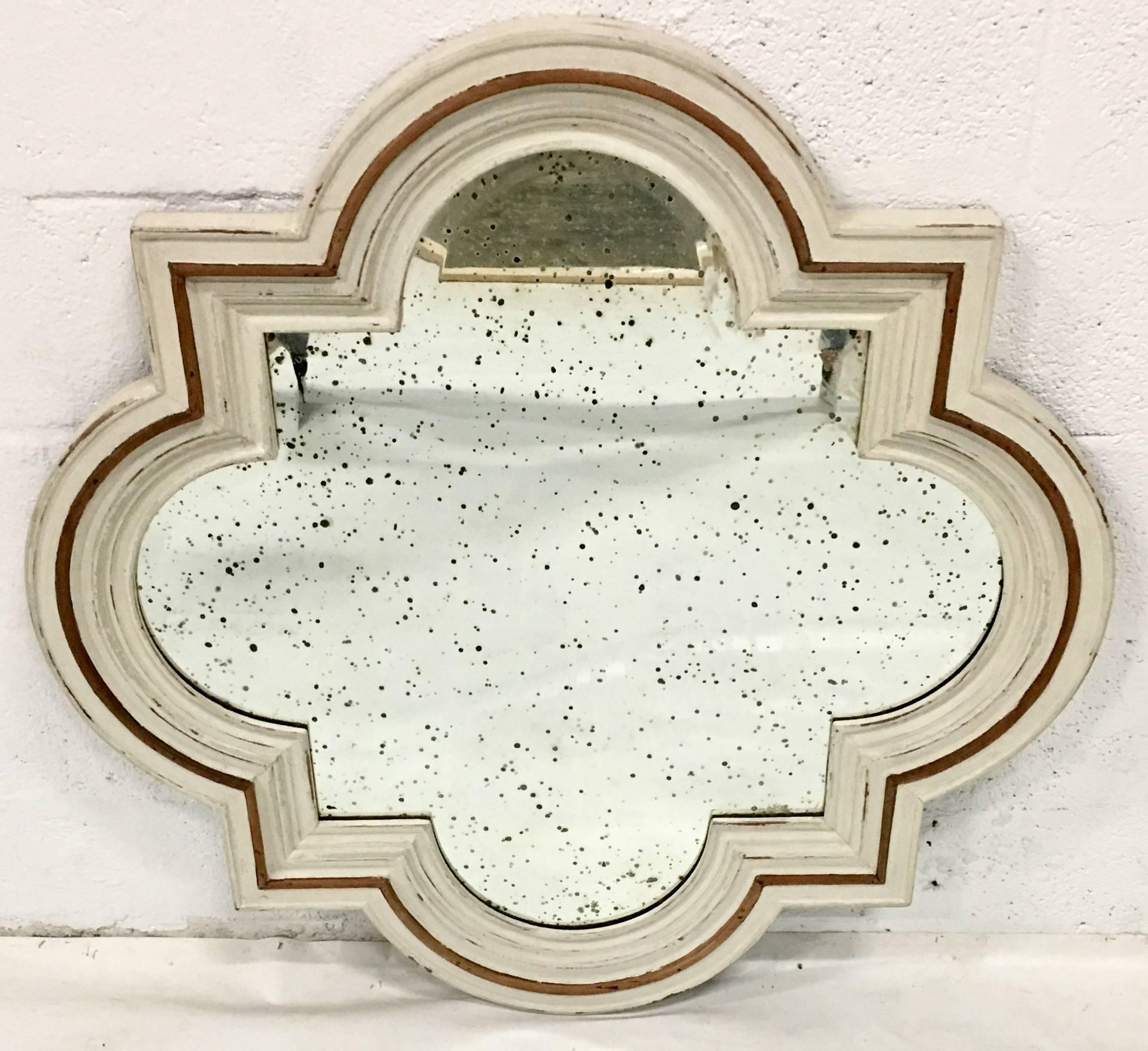 Vintage Italian carved and painted wood with raised applied detail quatrefoil antiqued glass mirror. Painted in off-white and terracotta.
