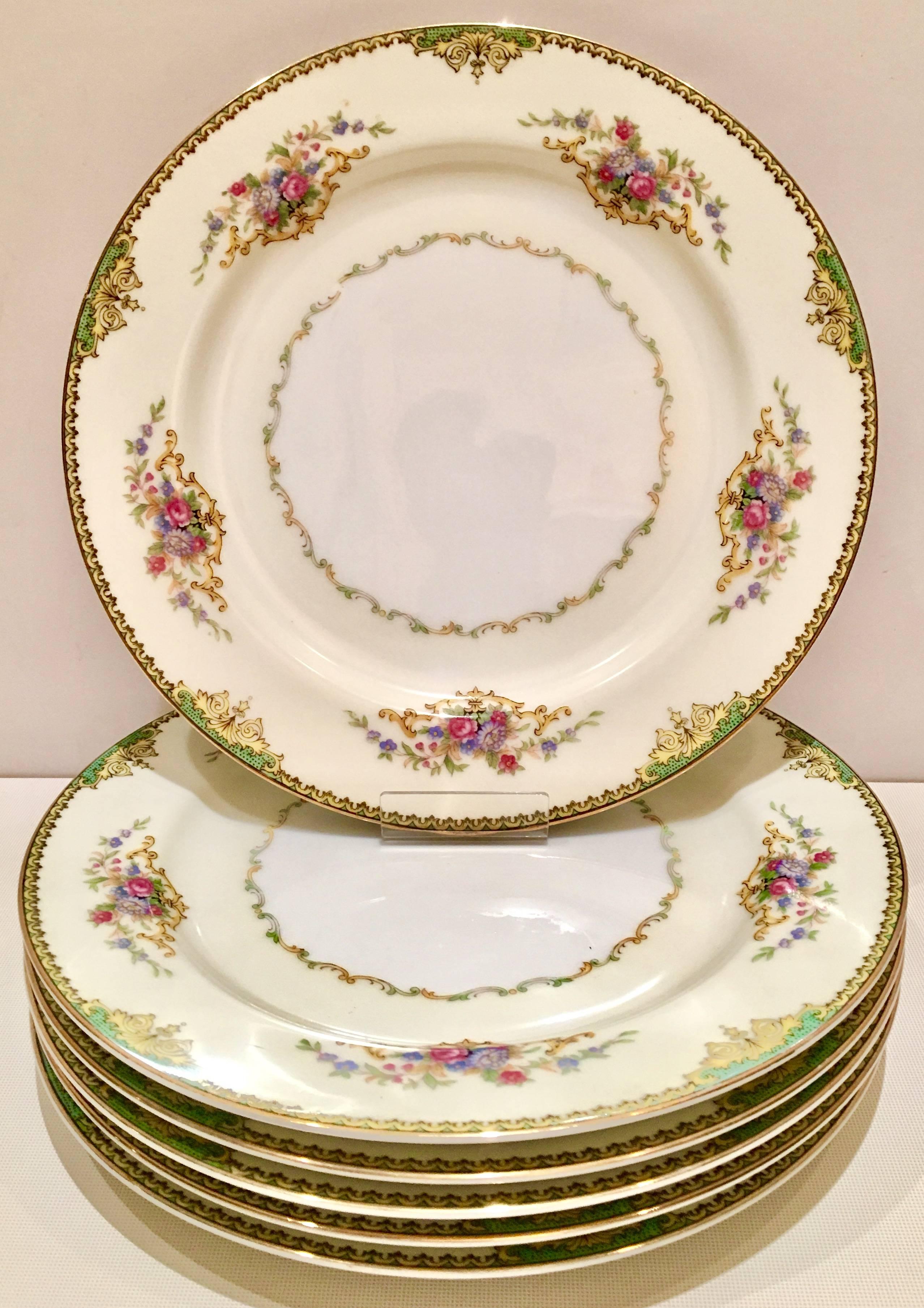 Art Deco porcelain pattern with a 22-Karat gold rim by Noritake Morimura Brothers Japan. Bright white ground with a cream border and gold, green and yellow rim, and pink and purple scroll floral pattern. Each piece is signed on the underside,